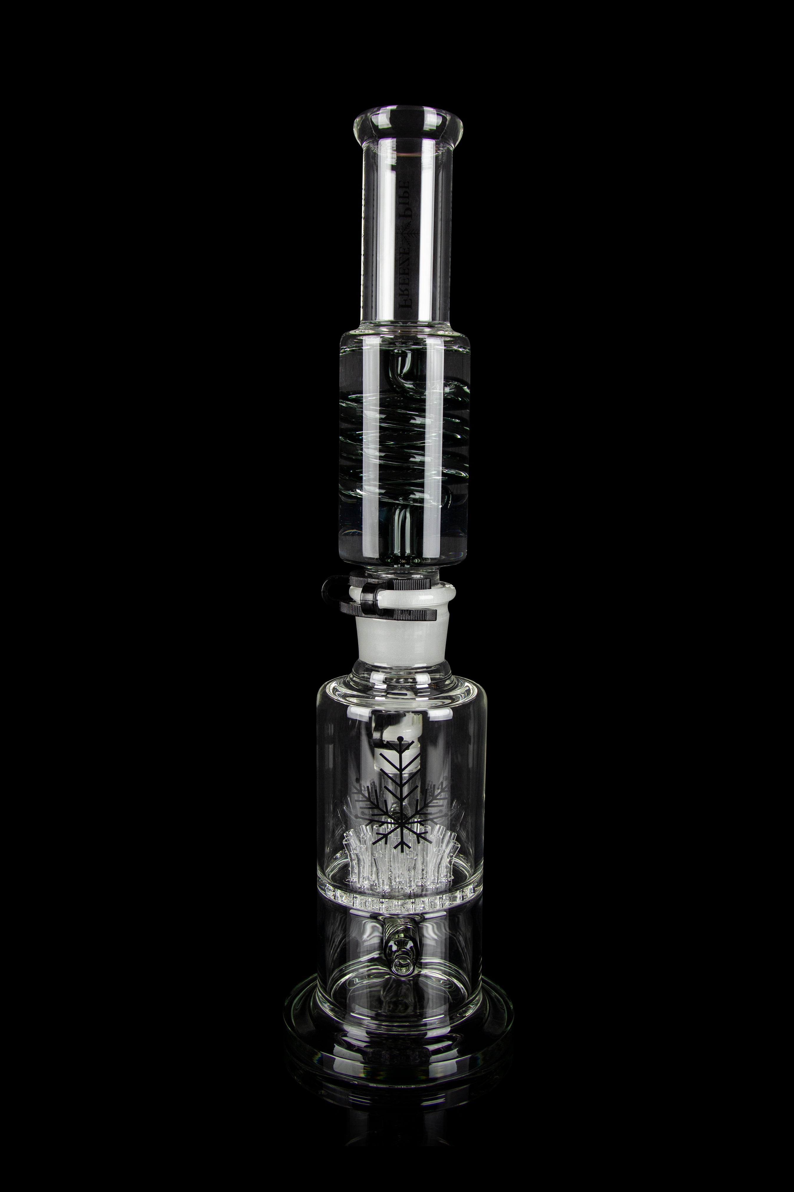 Clear glass water pipe (rig) with intricate design and bubbling filtration system, isolated on a black background.