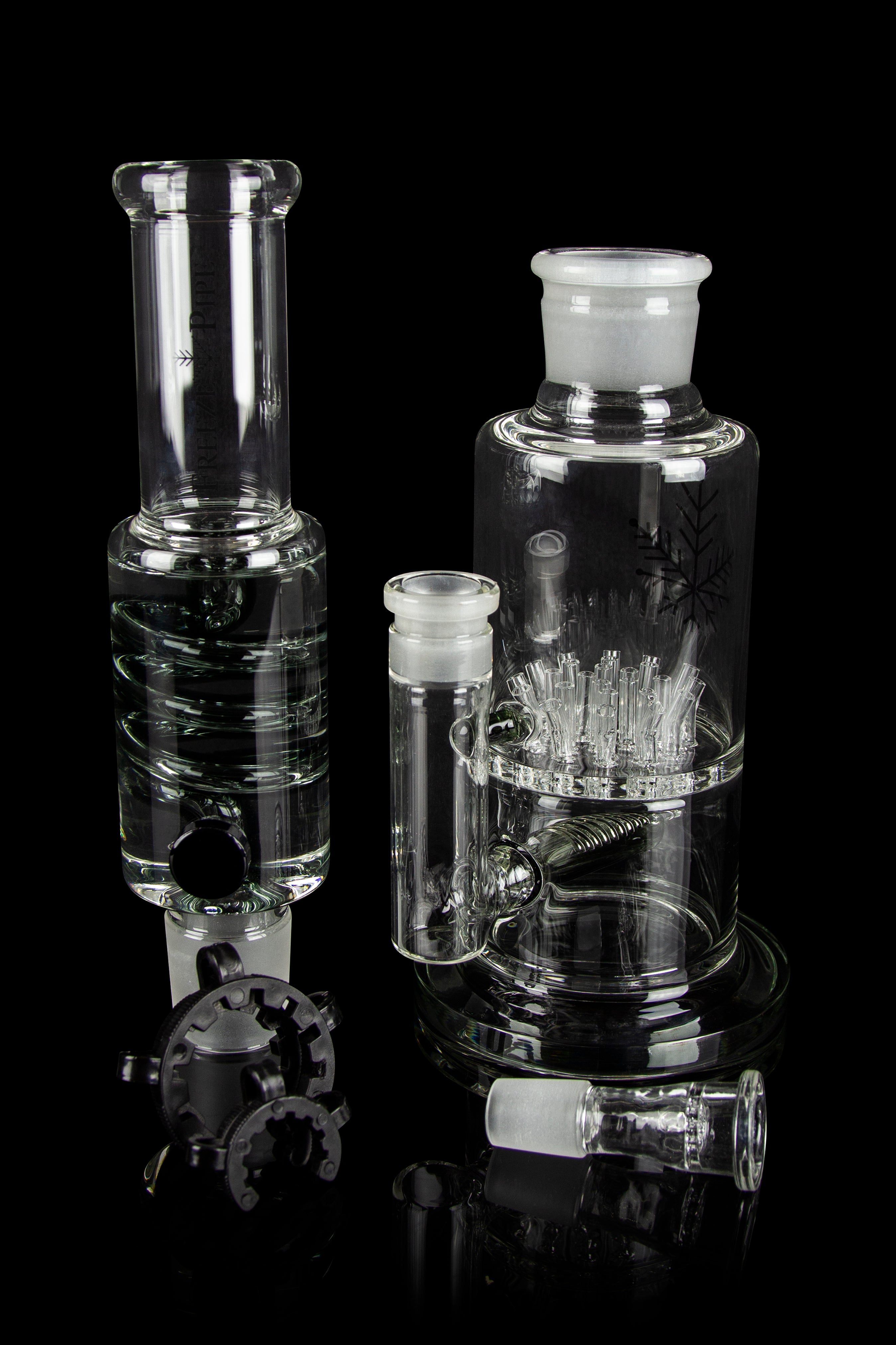 Clear glass water pipes and attachments on a black background.