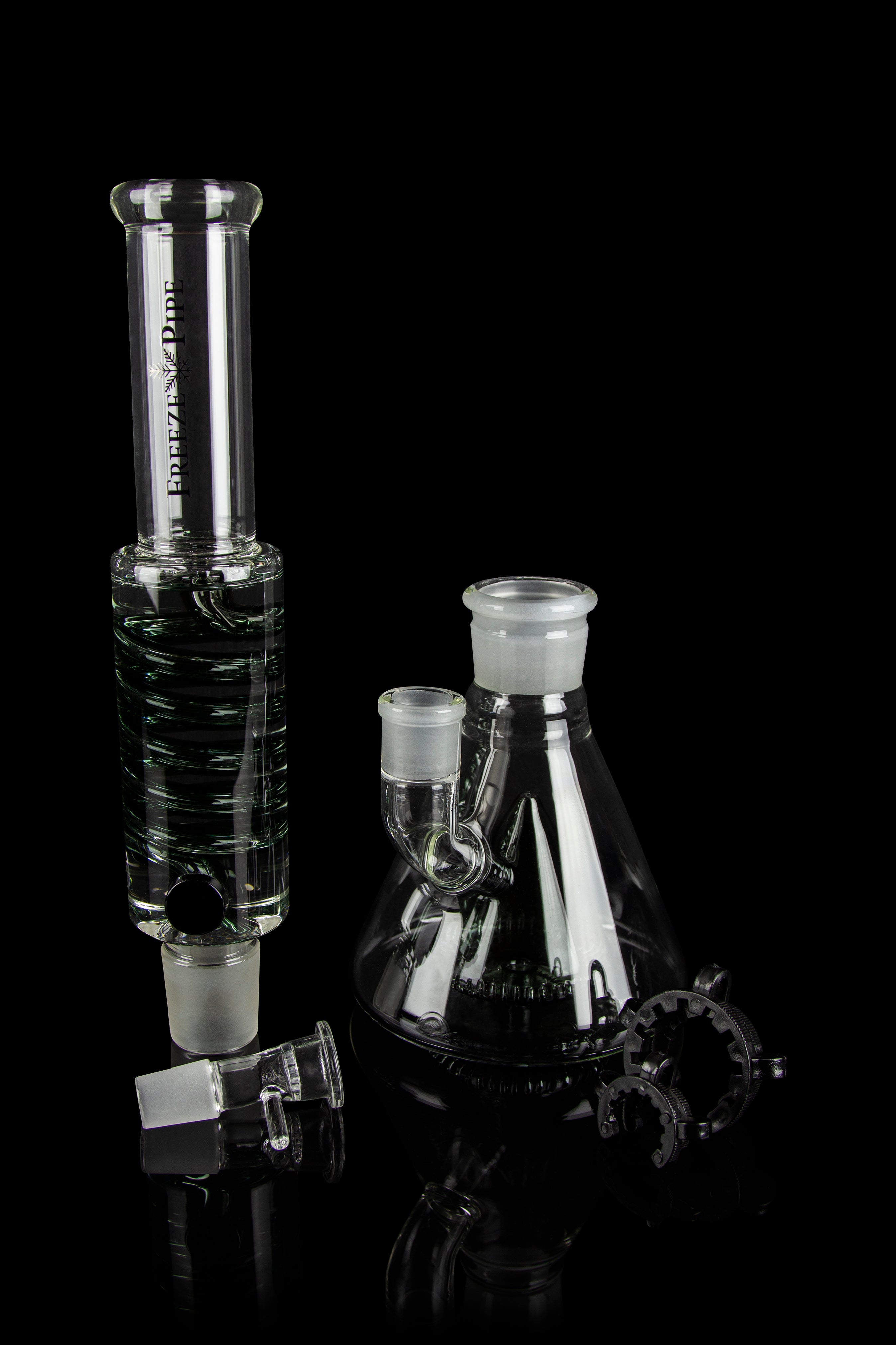 Glass water pipe (bong) and accessories on a black background.