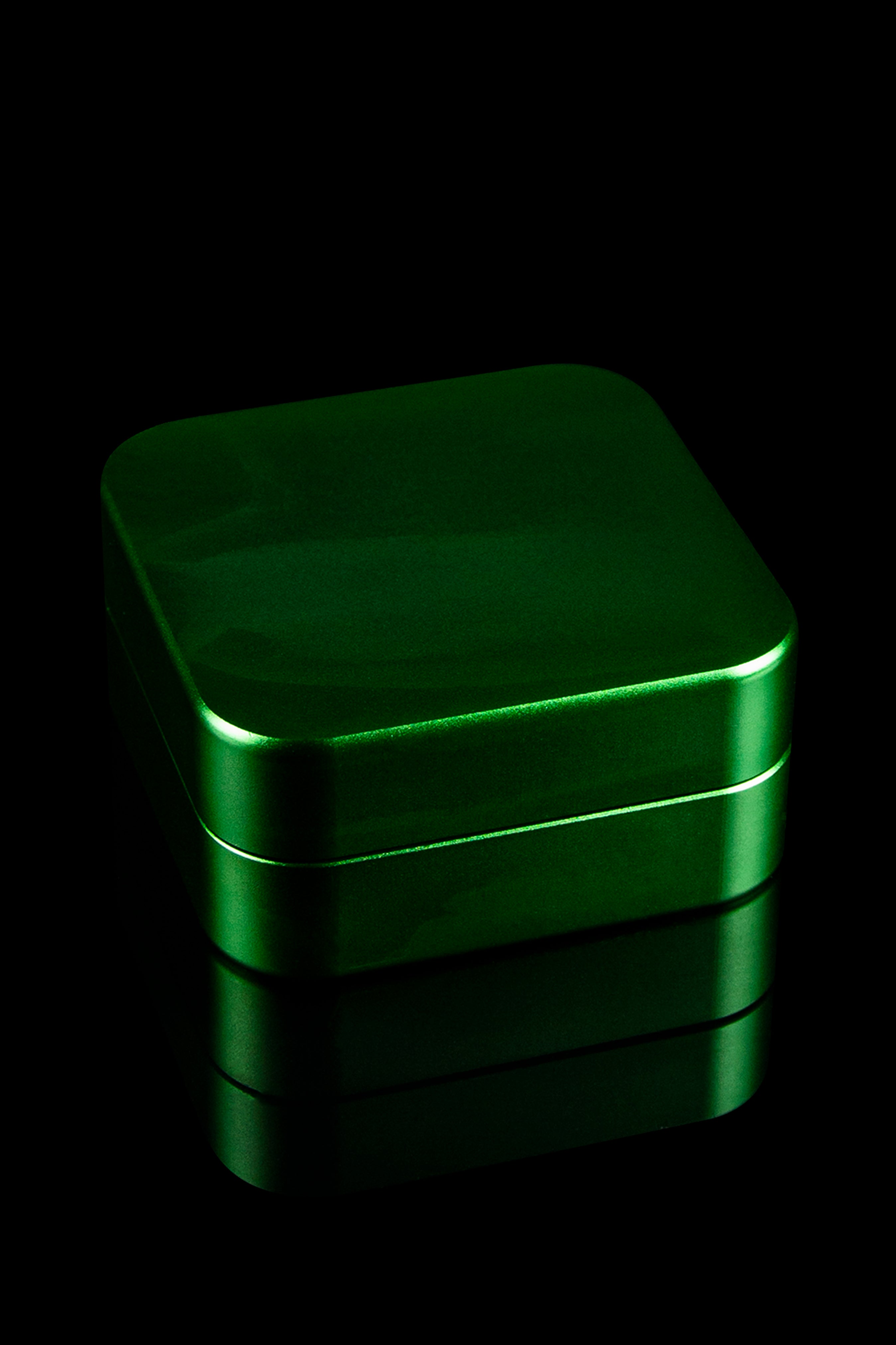 Green metal storage tin, likely for cannabis or accessories, against a black background.