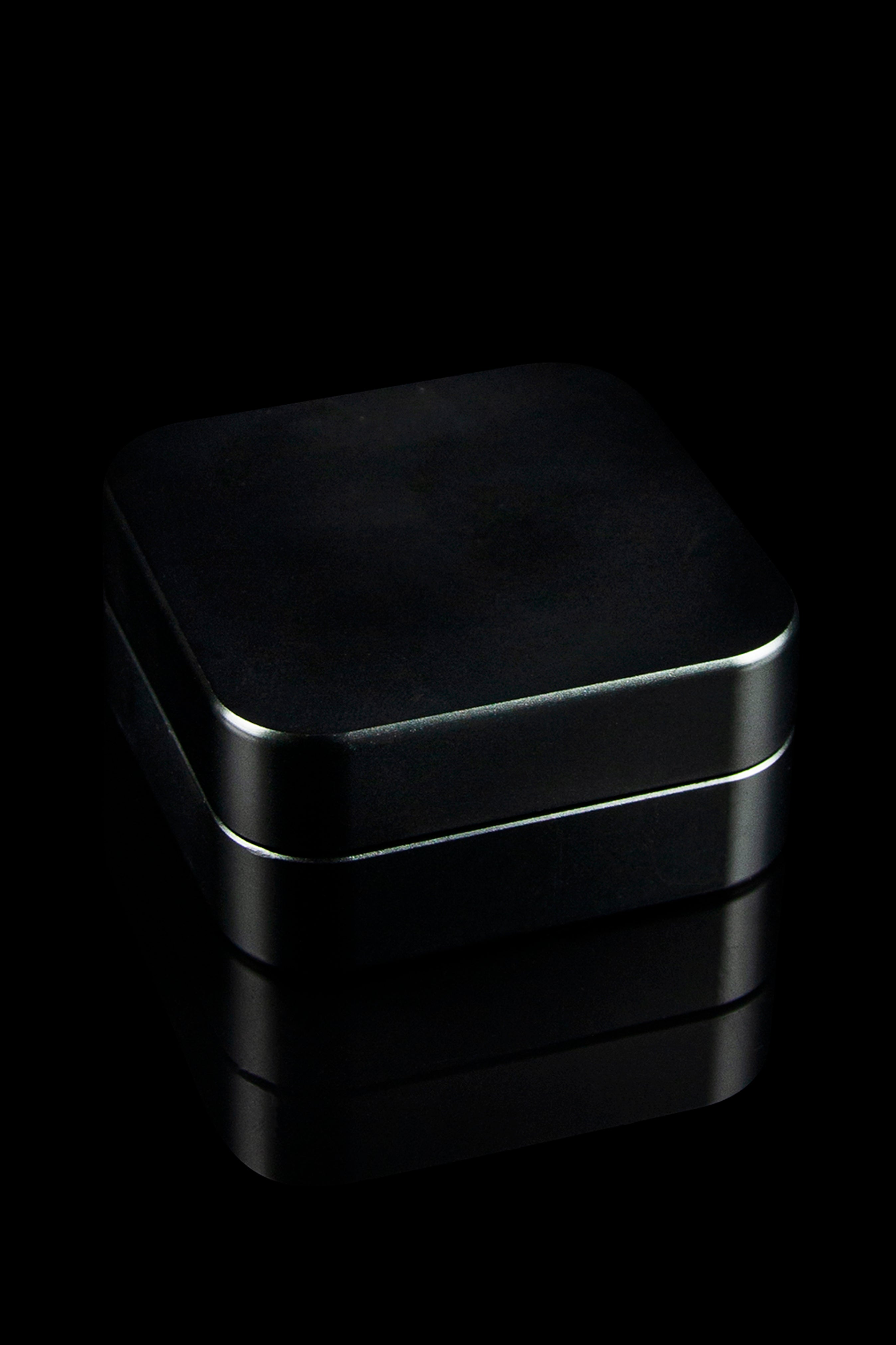Sleek black storage container, possibly for cannabis or accessories, dramatically lit against a dark background.