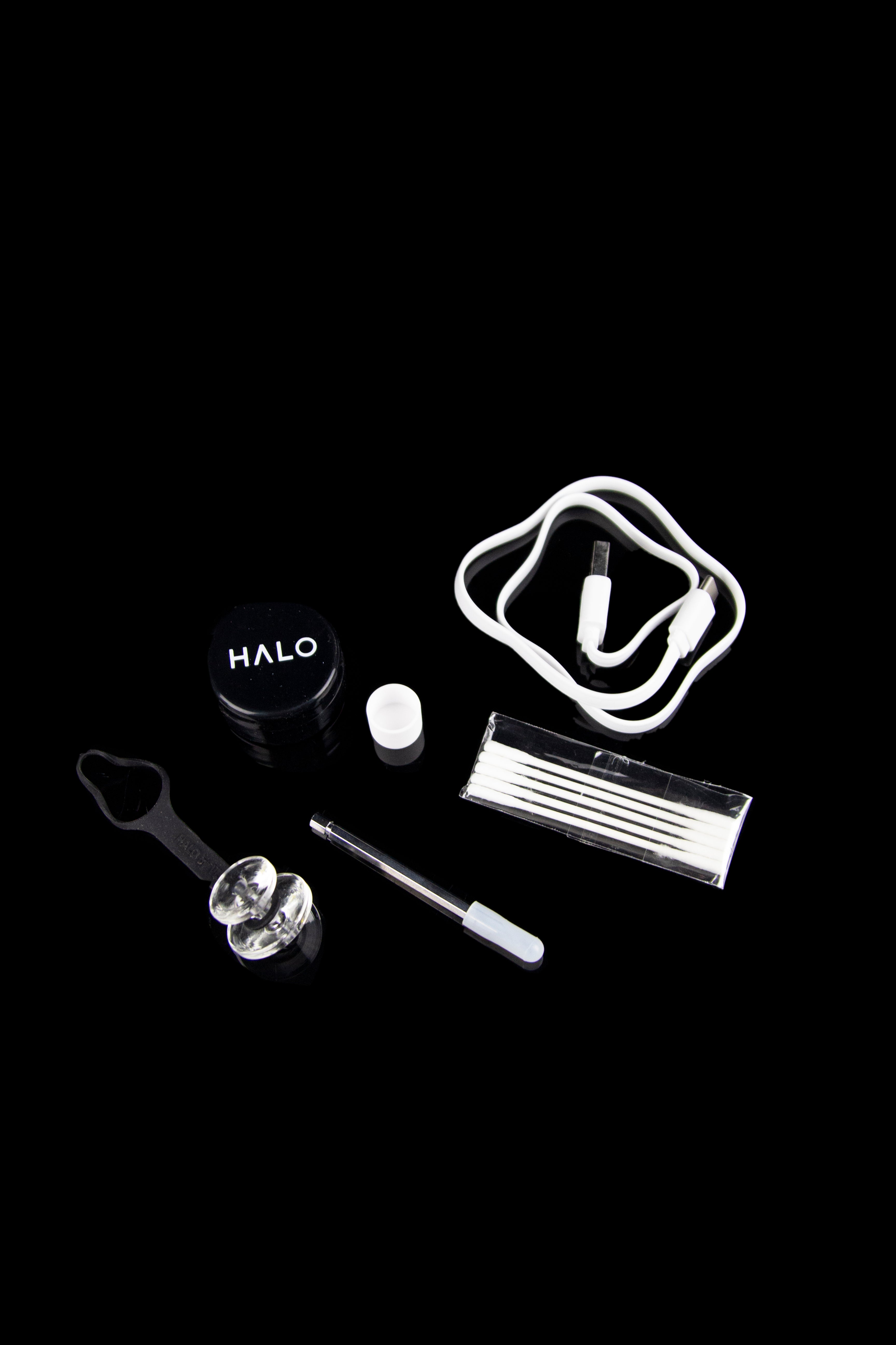 Cannabis vaporization device and accessories on a black background.