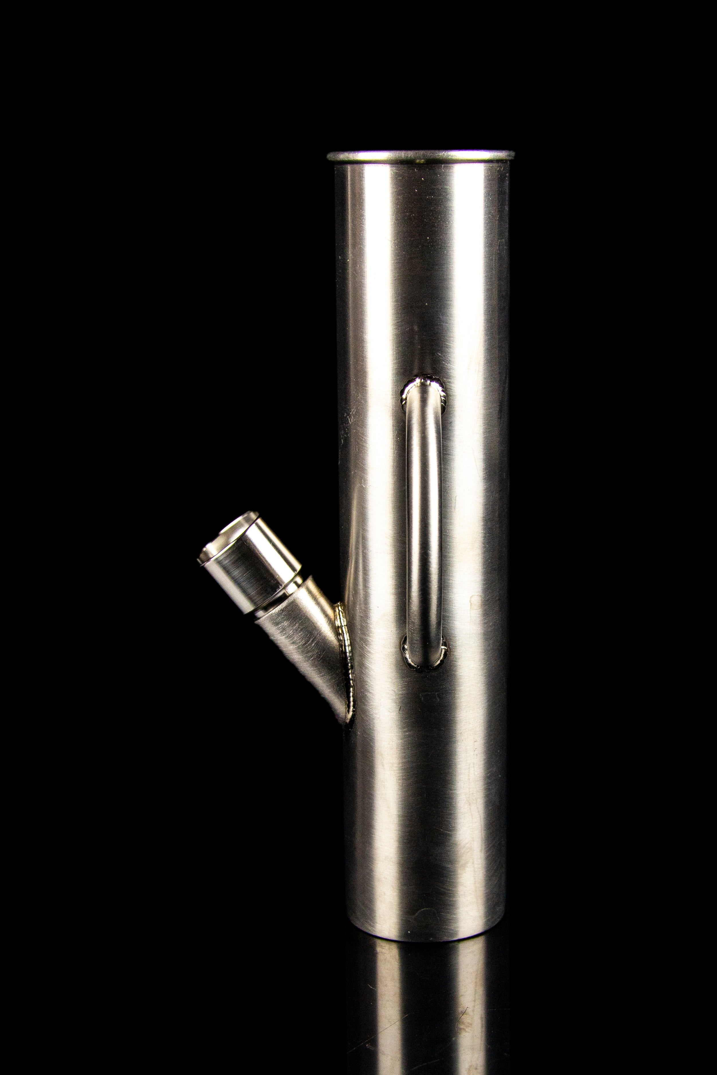 Polished metal oil burner pipe against a black background.