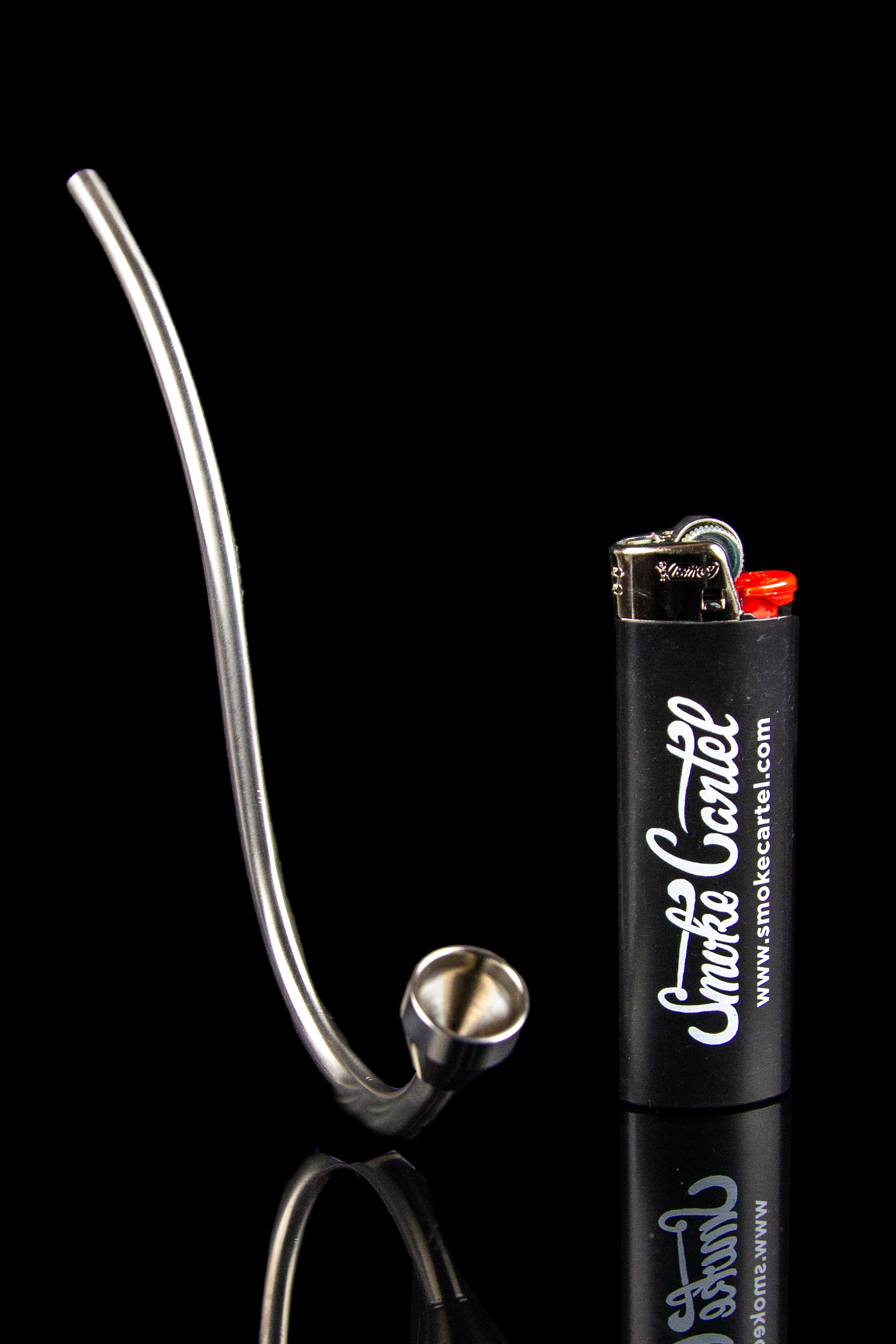 Silver glass pipe and lighter on a black reflective surface.