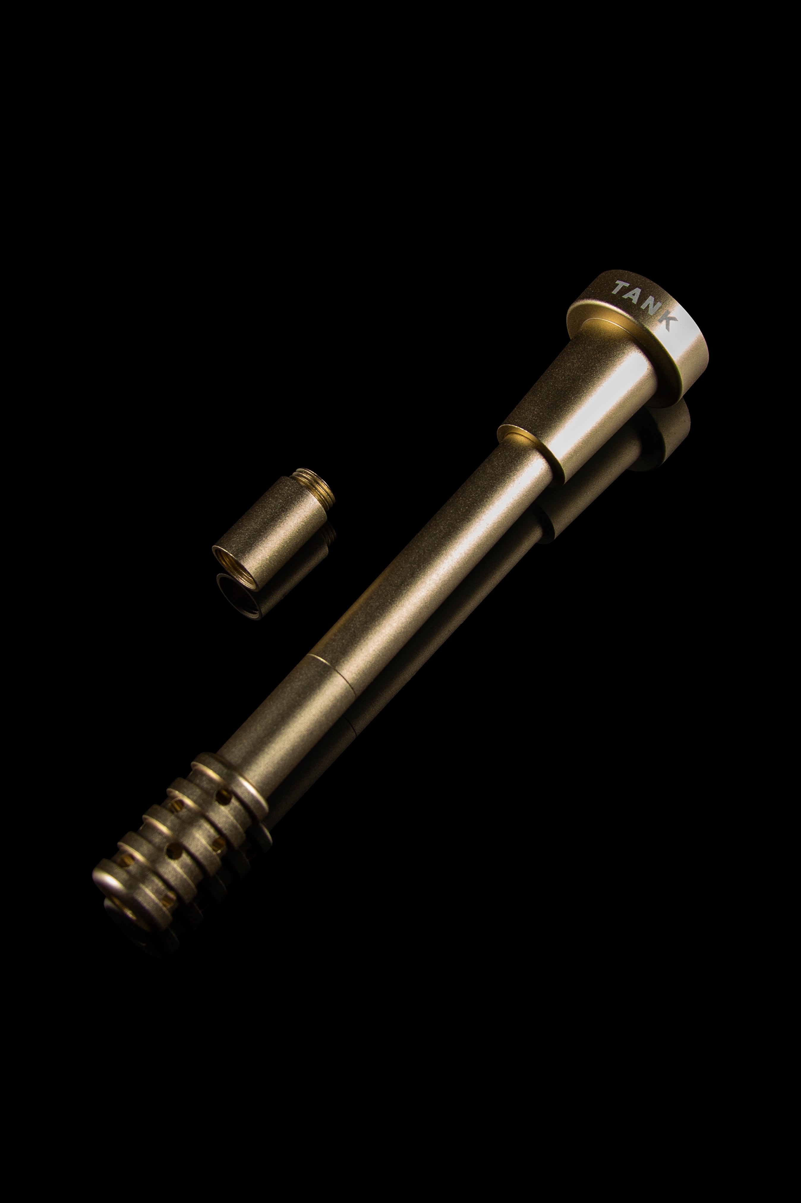 Gold cannabis dab tool with threaded tip and separate metal cap, isolated on black.