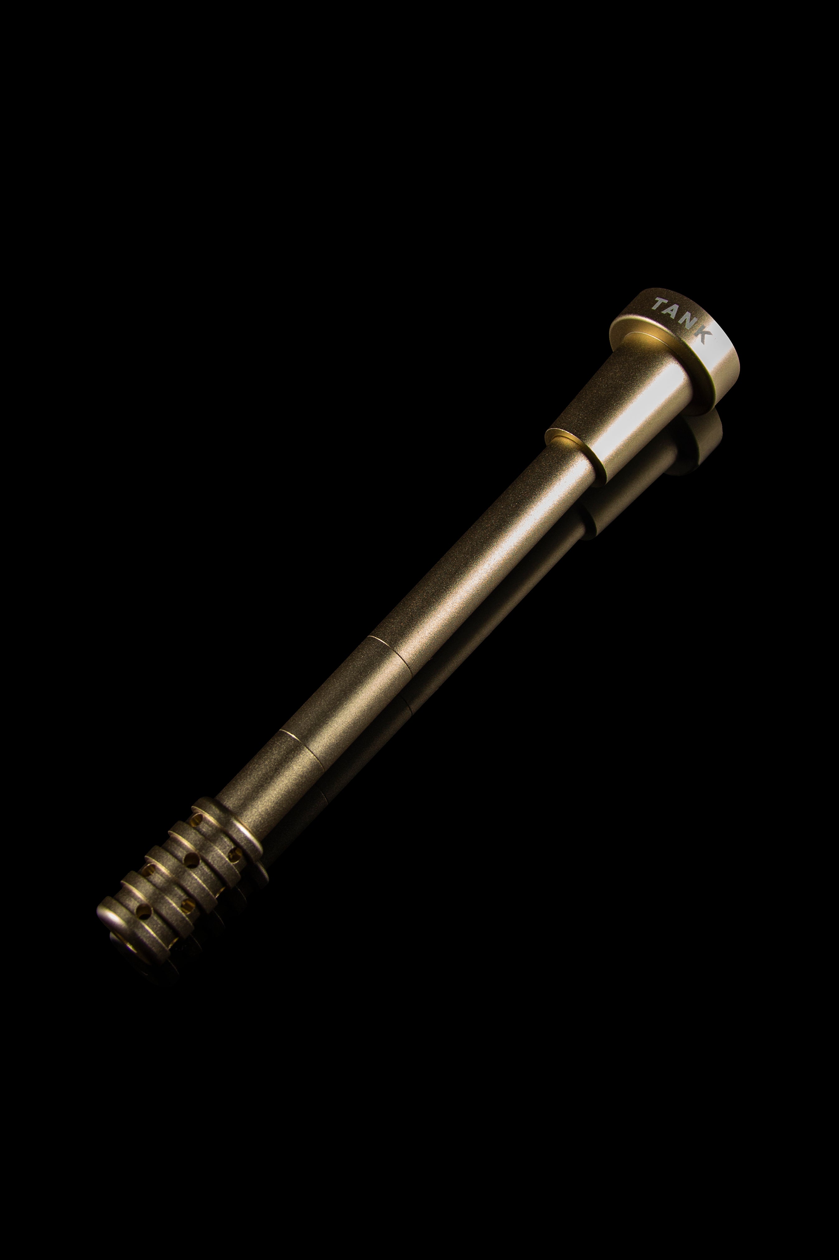 Gold cannabis oil syringe with threaded tip, isolated on black.