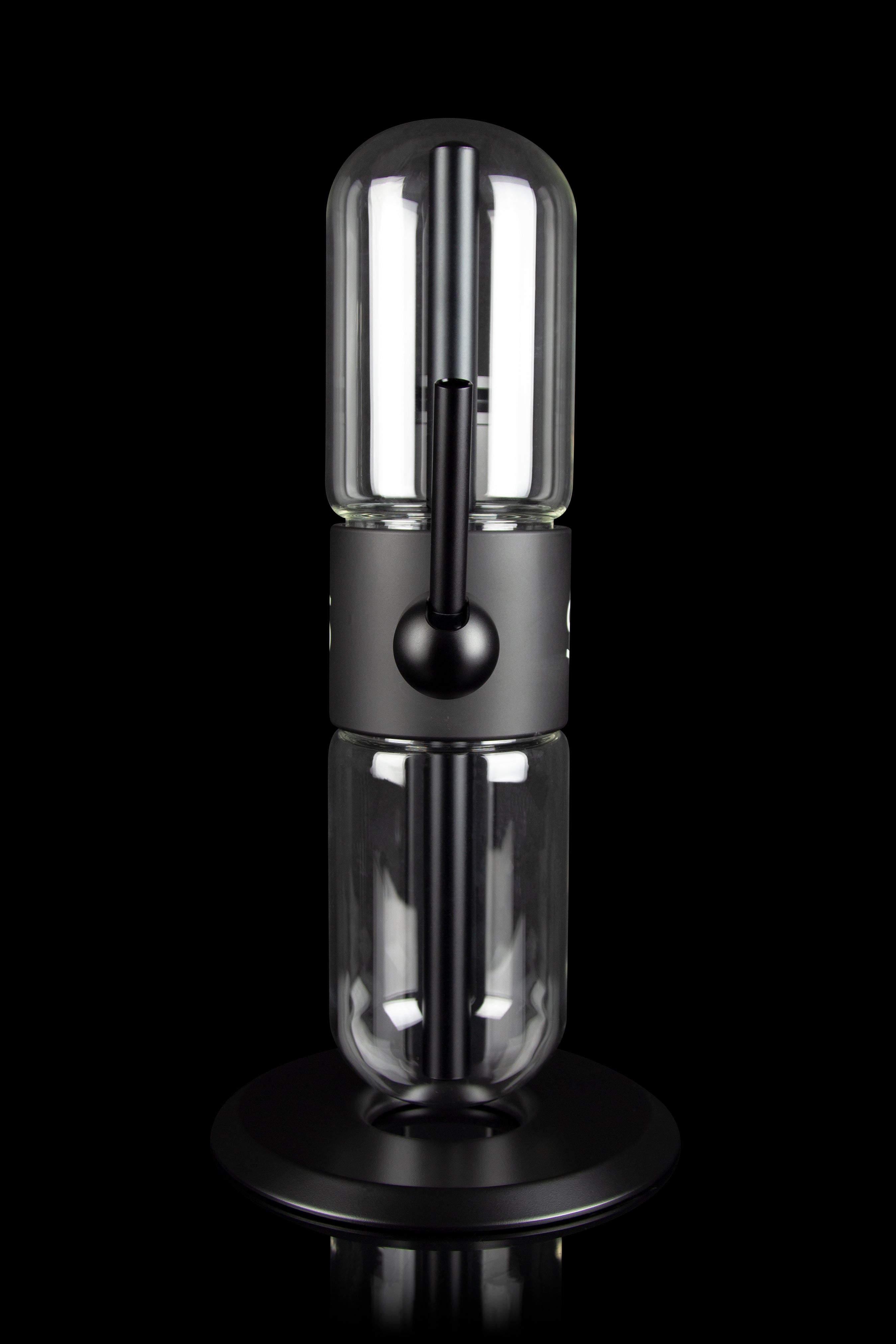 Sleek, black cannabis oil vaporizer (dab rig) with a glass chamber and illuminated heating element, displayed on a circular base.