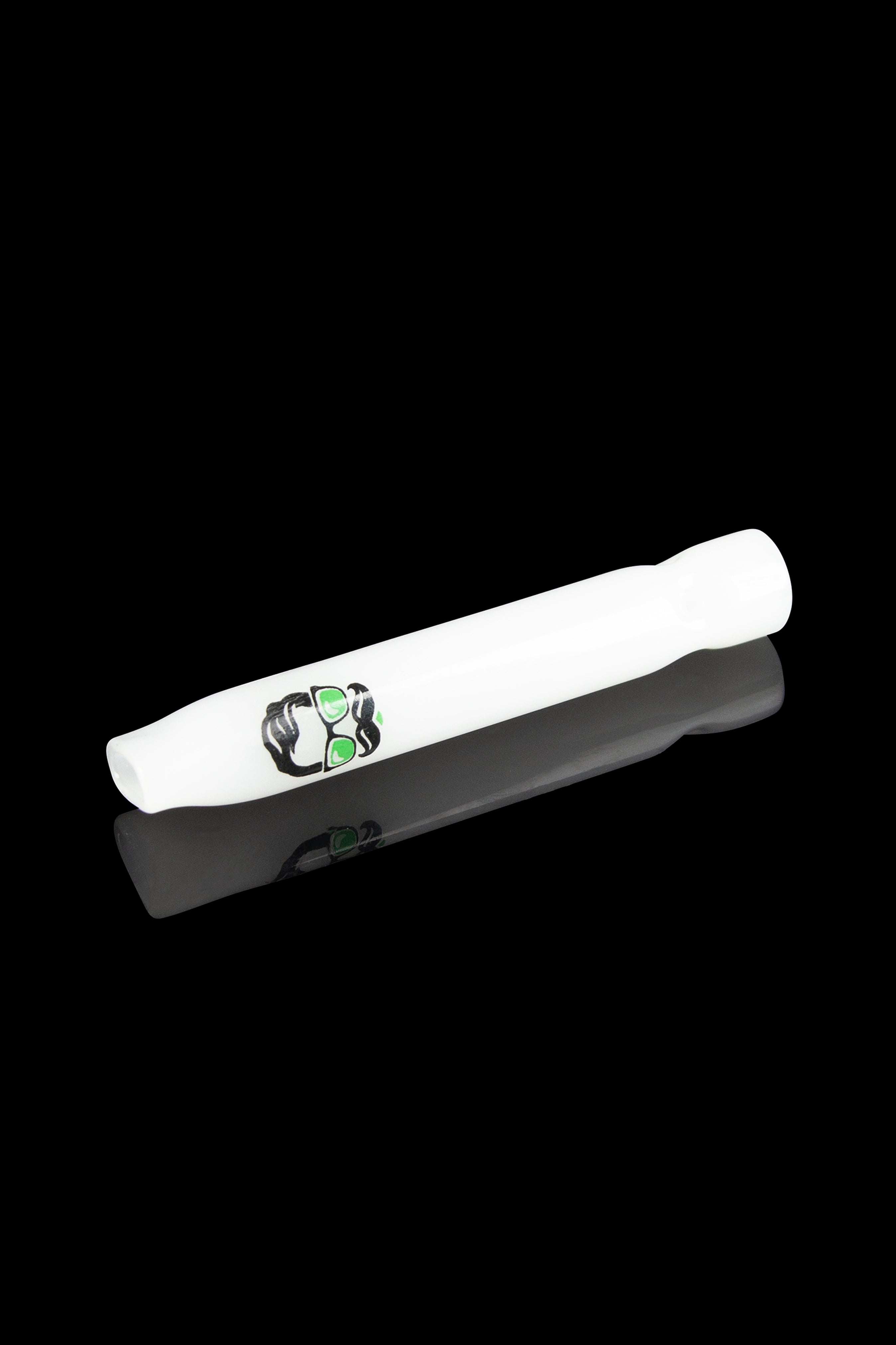 White glass cannabis pipe with green graphic, reflecting on a glossy surface.