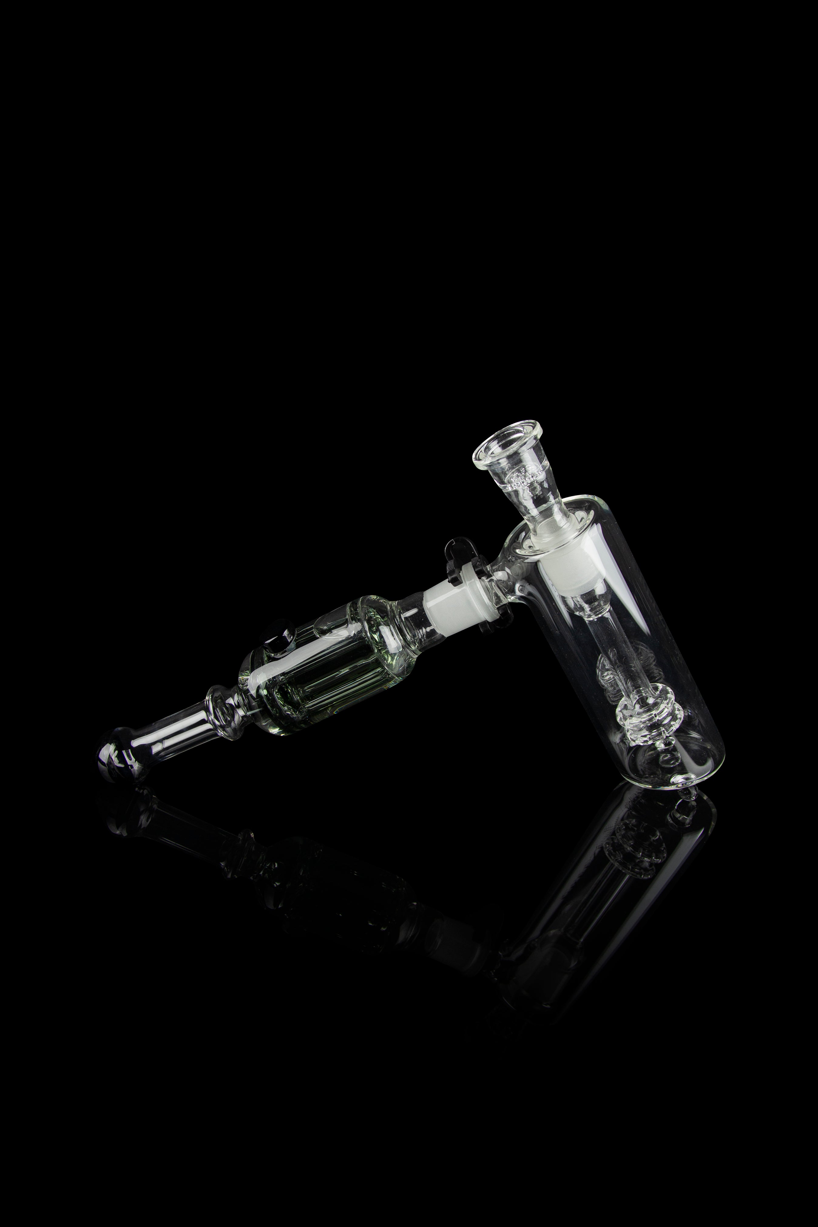 Clear glass rig with intricate bubbler and joint connection, isolated on black.
