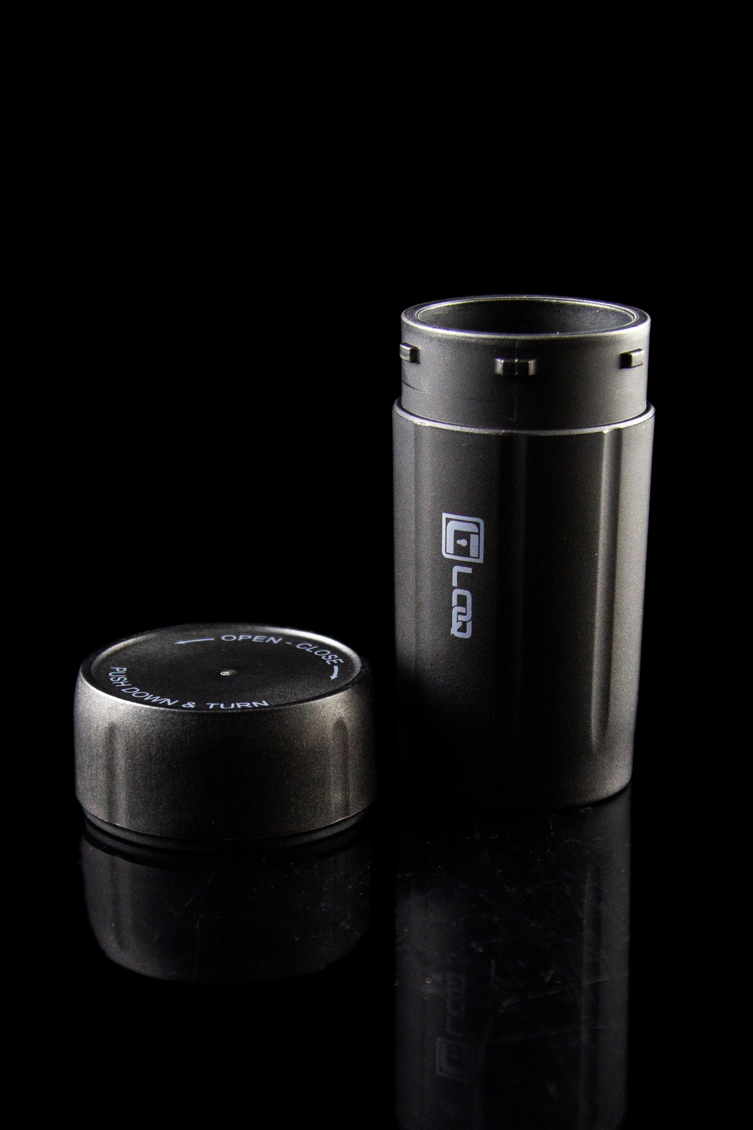 Black cannabis oil vape pen with open/close cap displayed on a reflective surface.