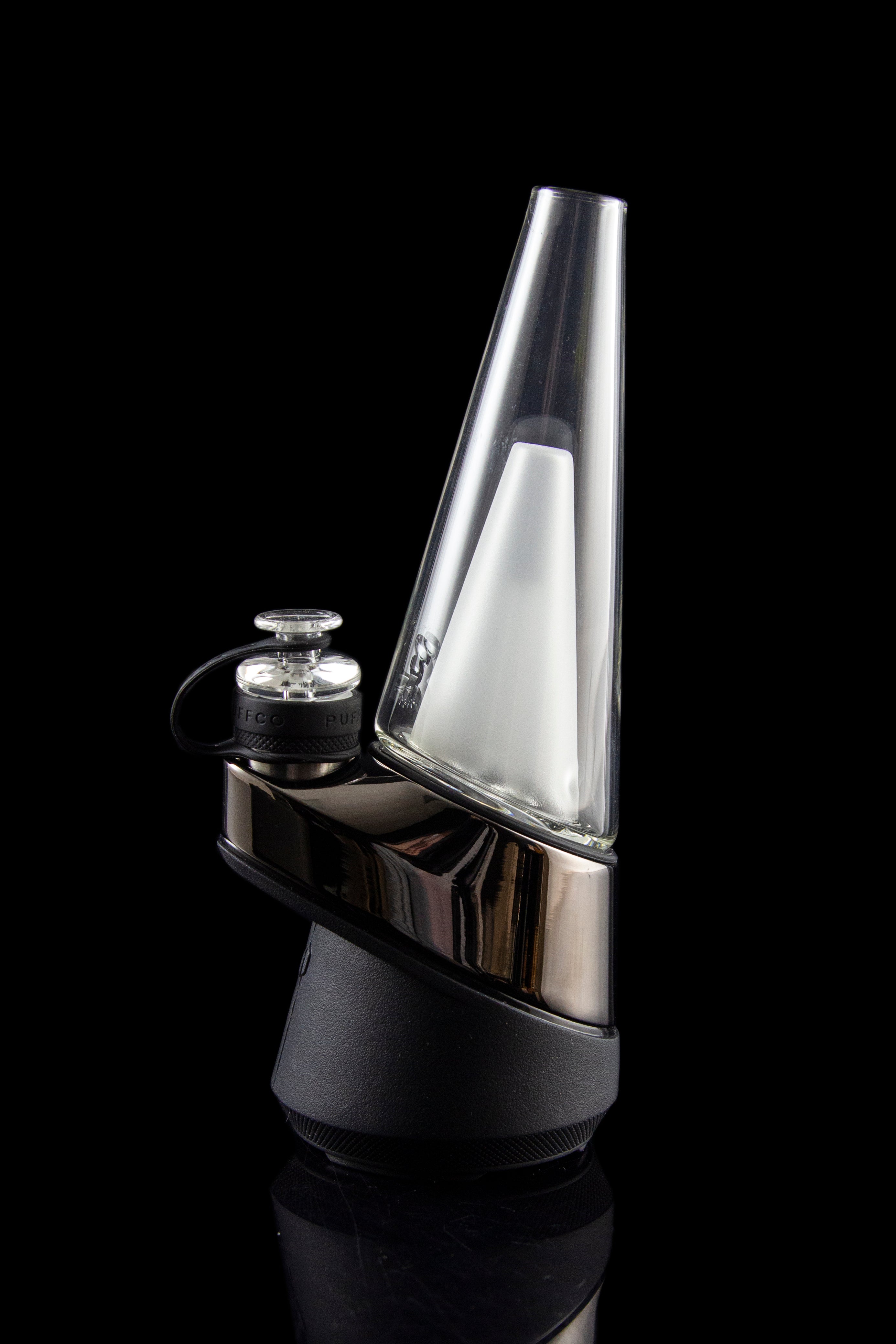 Sleek, silver cannabis dab rig with a conical glass chamber and black base, reflecting light on a dark background.