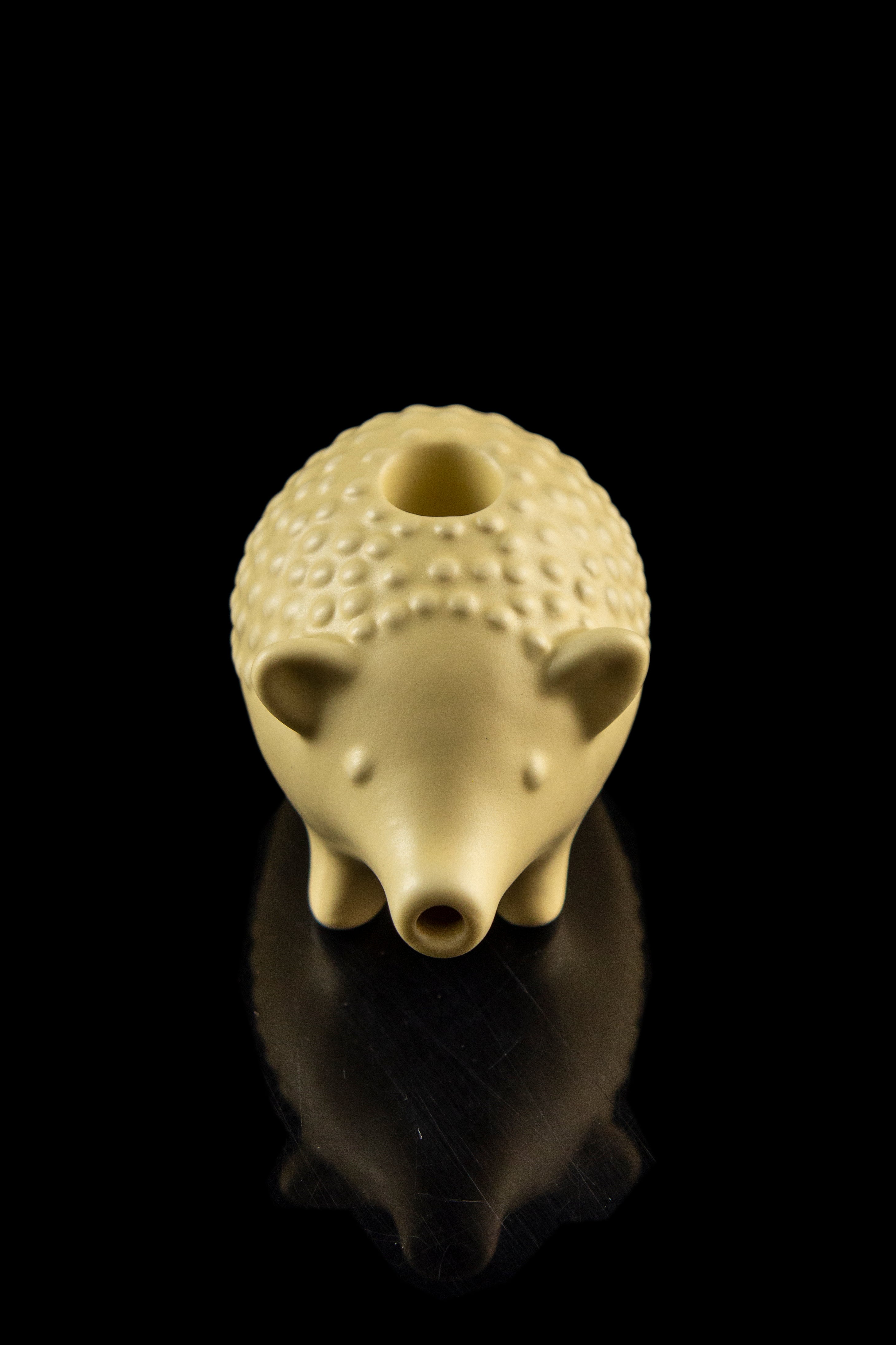 Ceramic pipe shaped like a hedgehog with a glossy finish, displayed against a black background.