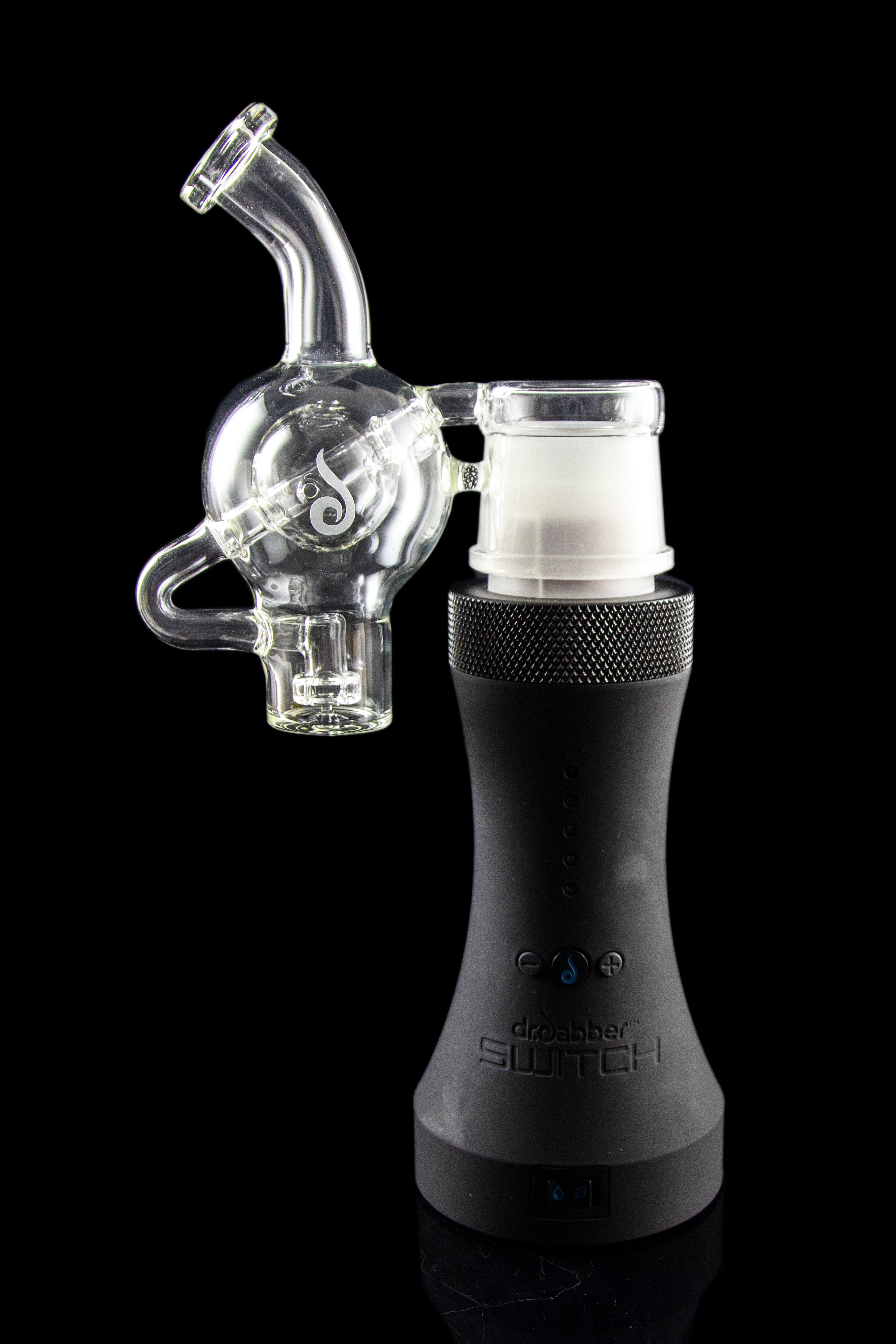 Clear glass bubbler attachment connected to a black electronic dab rig, reflecting on a glossy surface.