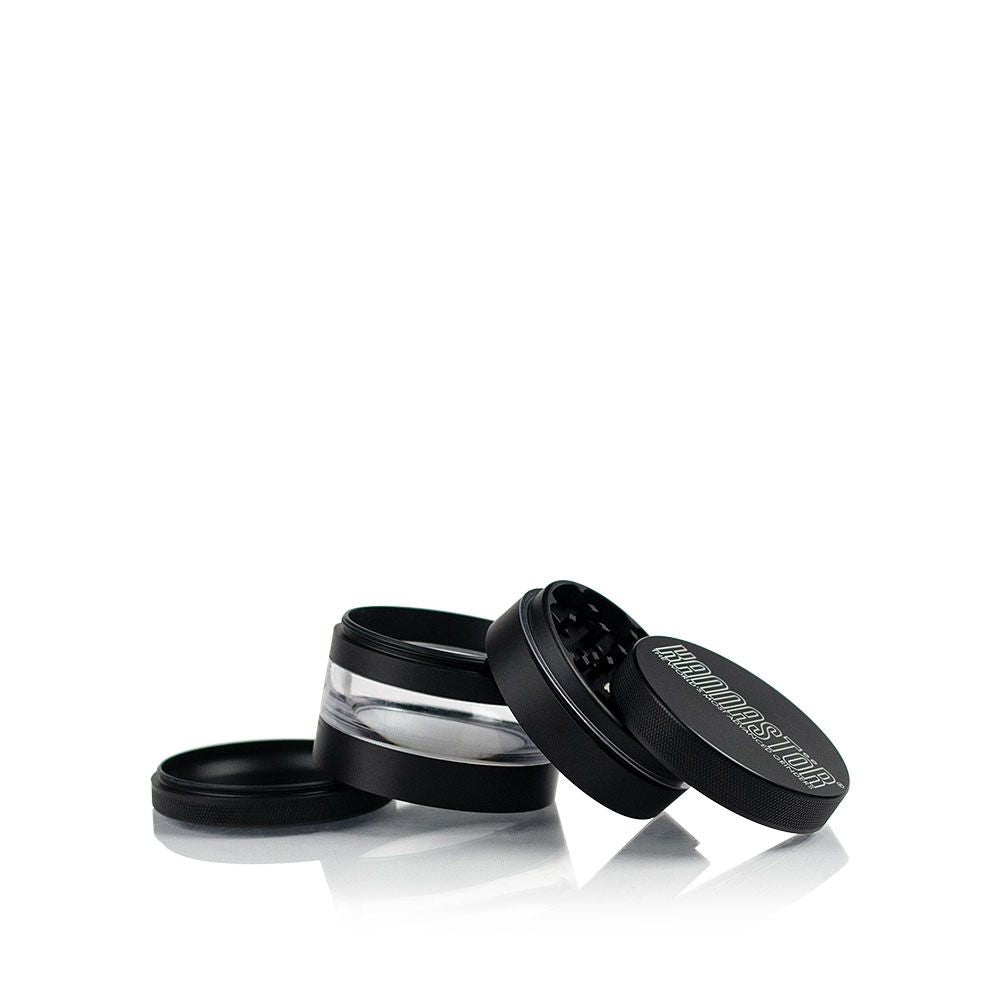 A partially open Kannastor 2.5" 4-Piece Grinder with Monofilament EZ Screen is displayed at a slight angle on a dark surface.