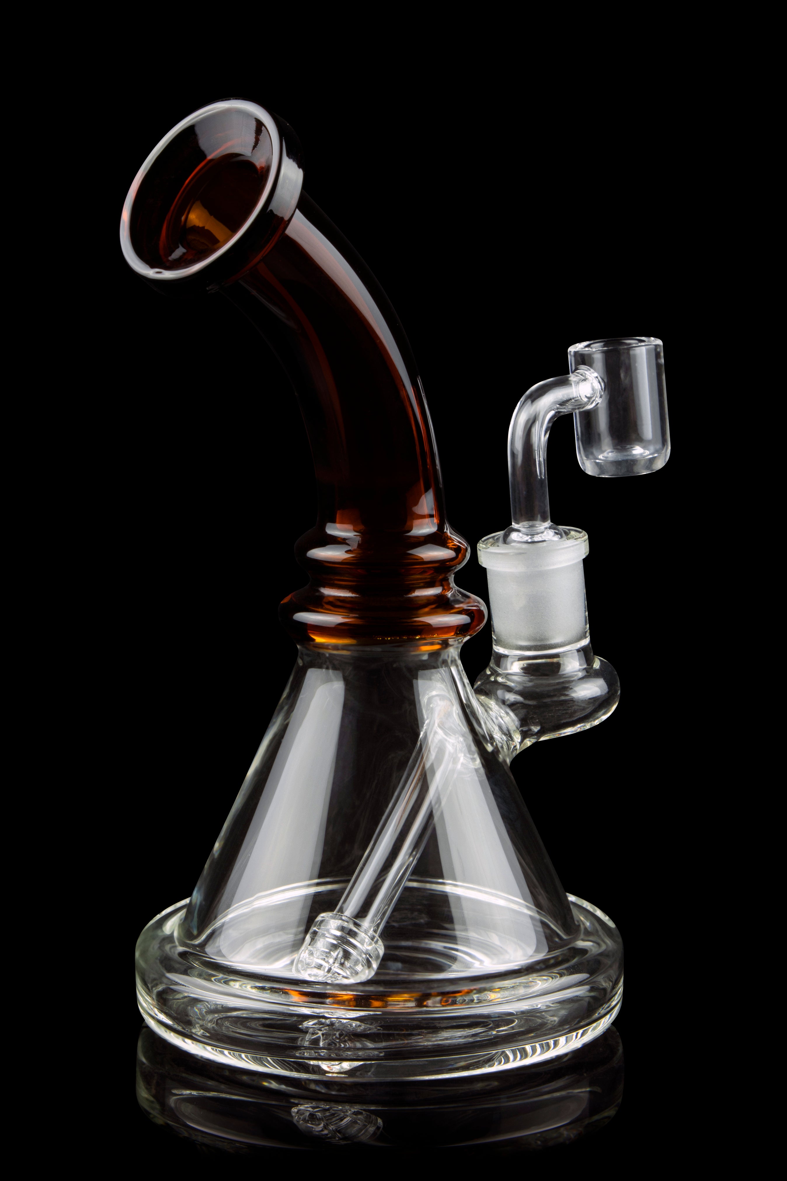 A clear glass water pipe (rig) with a colored mouthpiece and a quartz nail for vaporizing concentrates, isolated on a black background.