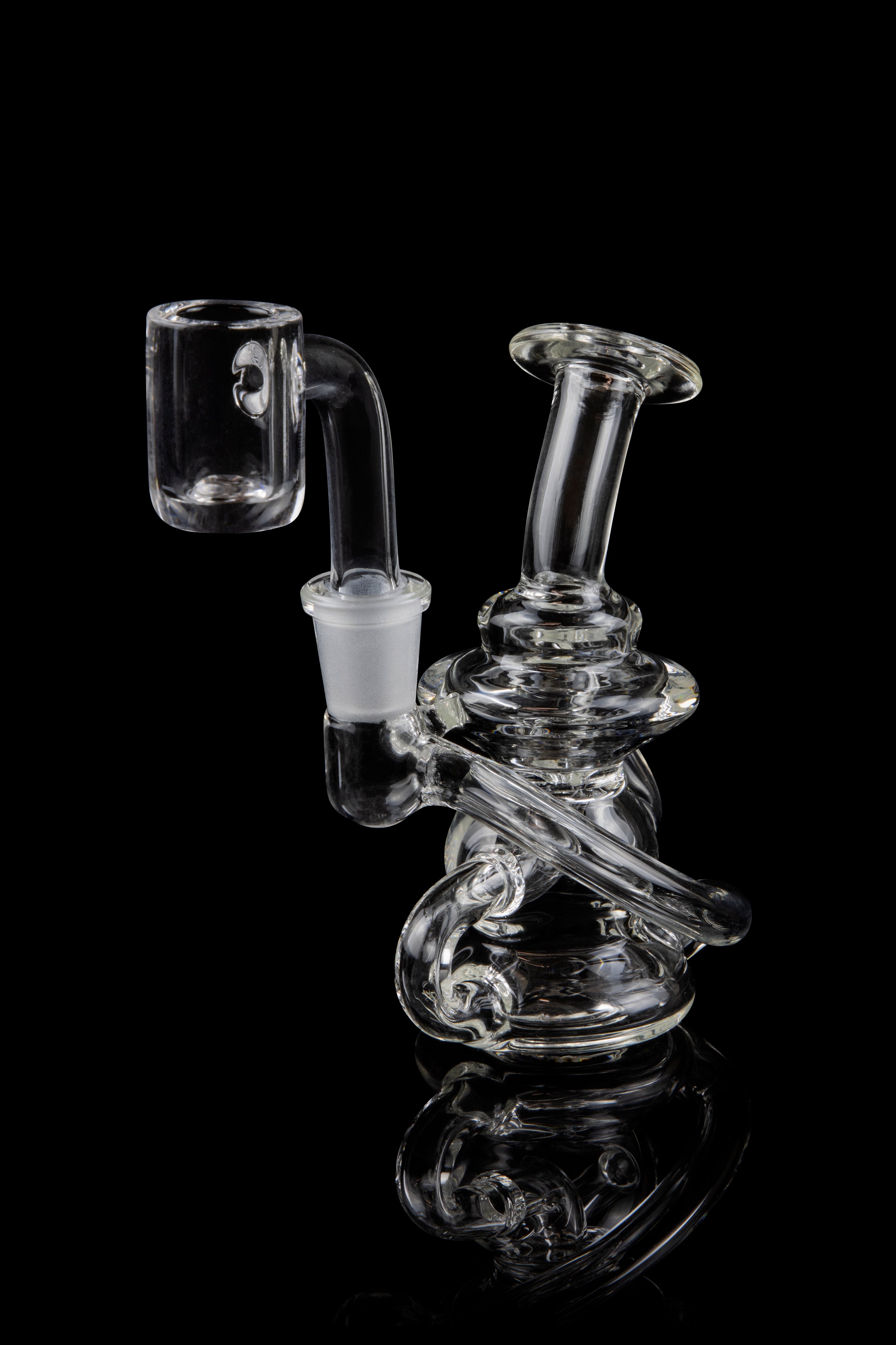 Clear glass dab rig with intricate design and quartz banger.