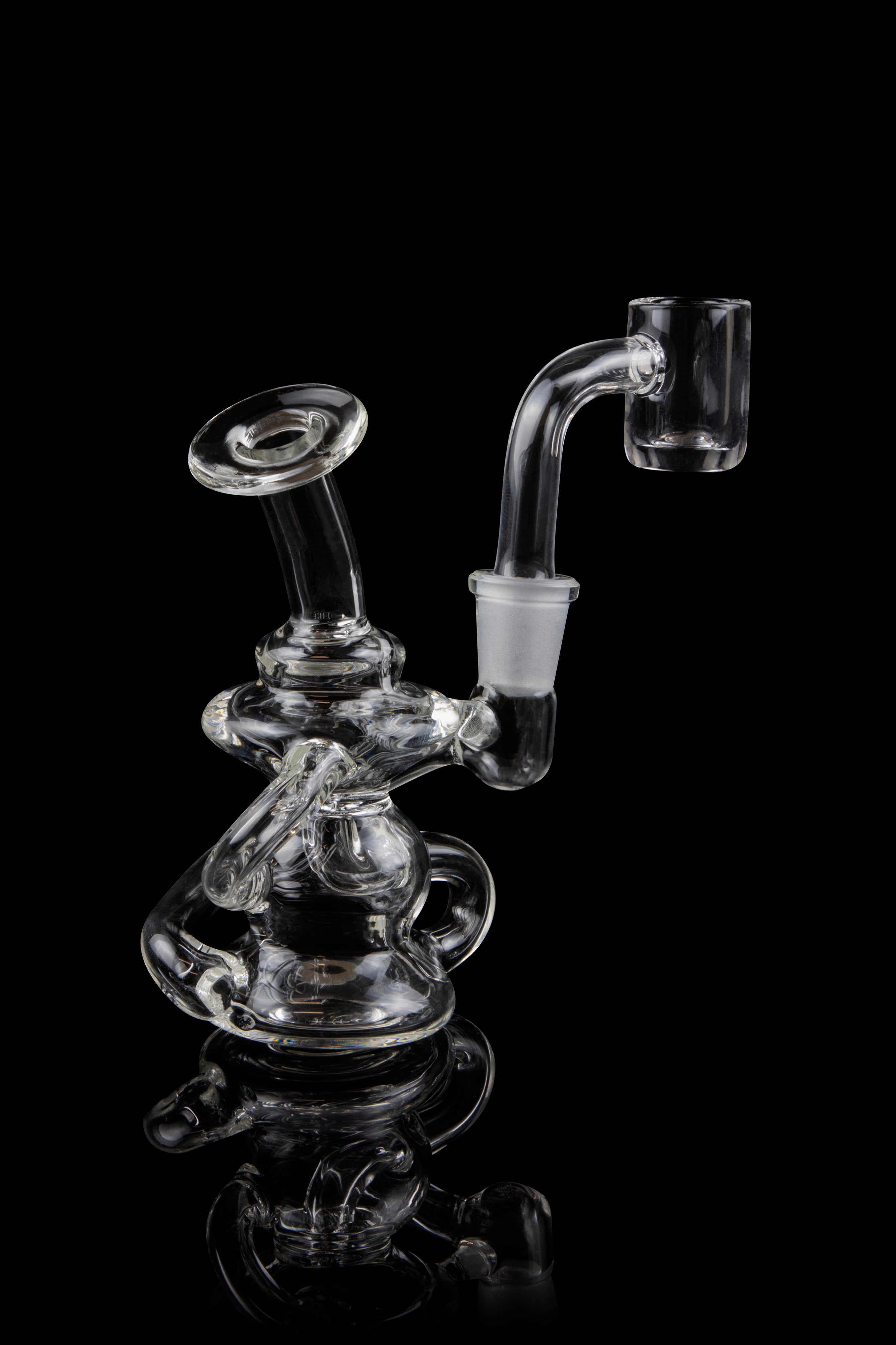 Clear glass dab rig with intricate sculptural design, reflecting on a black surface.