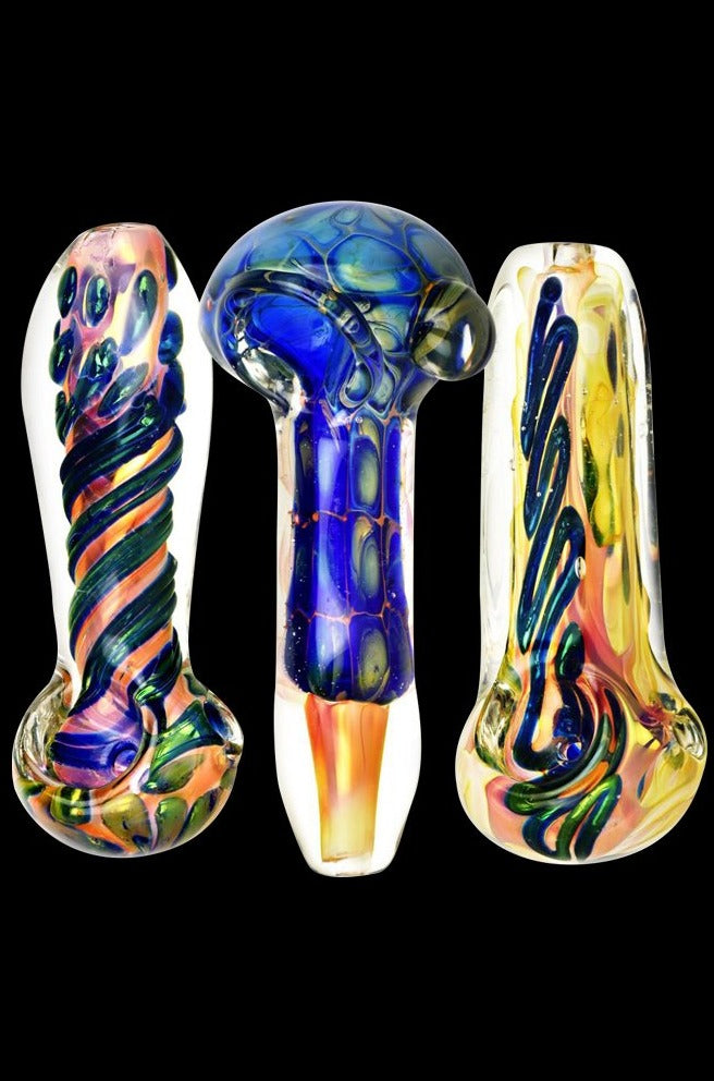 Three fumed glass spoon pipe pieces in an aqua sea turtle shell style are shown upright against a black background, the central Fumed Glass Spoon Pipe displaying a rounded blue head and swirling iridescent patterns.
