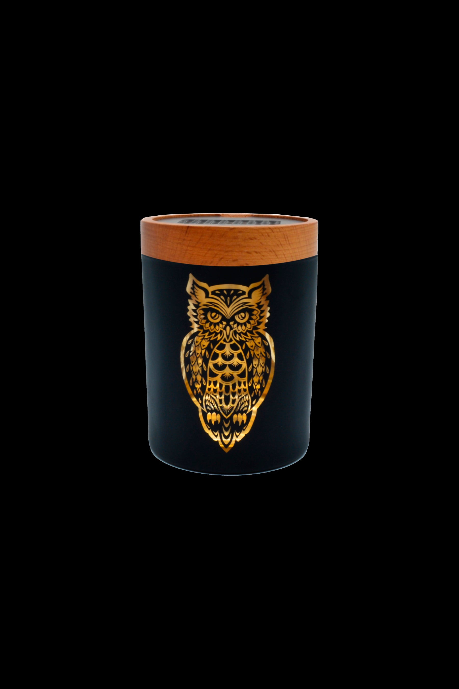 Black glass cannabis storage jar with a gold owl design and wooden lid.