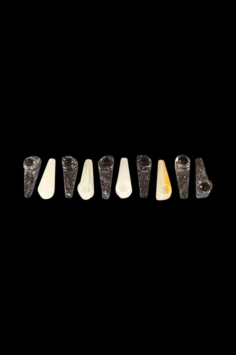 Row of small black and white Onyx Stone Smoking Pipe pieces shown head-on on a solid black background.