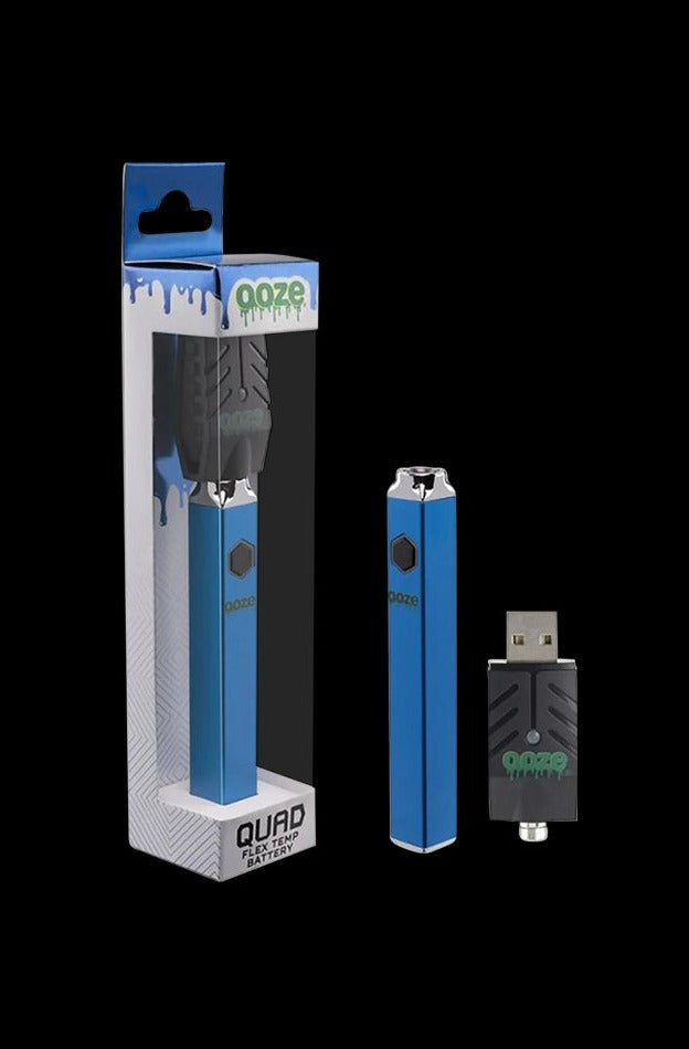 Product shot of the Ooze Quad Flex Temp Vape Pen 510 Battery in metallic blue beside its matching USB charger and retail box on a black background