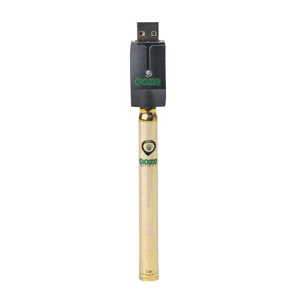 Center-aligned studio shot of an Ooze Slim Twist Battery with Charger showing the gold slim battery upright with its black USB charger attached against a white background