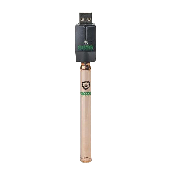 Centered, front-facing shot of the Ooze Slim Twist Battery with Charger showing a rose-gold slim battery with green logo and its black USB charger plugged on top against a white background