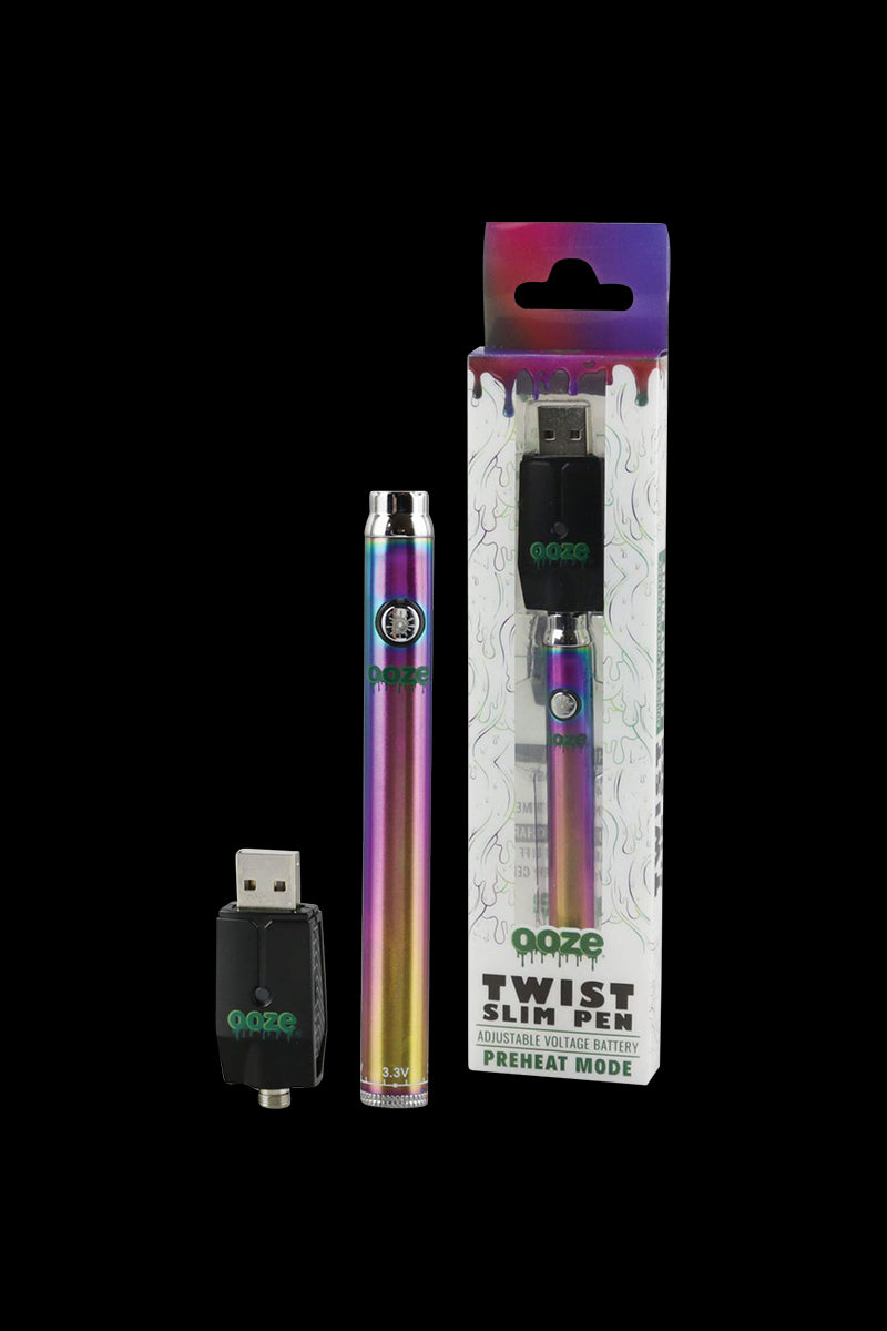 Front-facing shot of the Ooze Slim Twist Battery with Charger showing a rainbow-metal slim pen battery, USB charger, and matching retail box on a black background