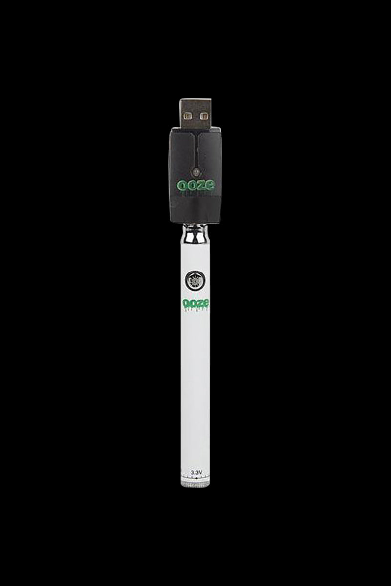Centered vertical shot of the silver Ooze Slim Twist Battery with Charger against a solid black background showing the USB charger attached.