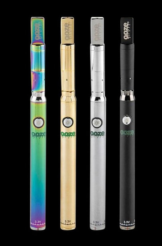 Vertical front view of four Ooze Slim Twist PRO Concentrate Vape Kit pens in metallic rainbow, gold, silver, and matte black lined up against a black background.