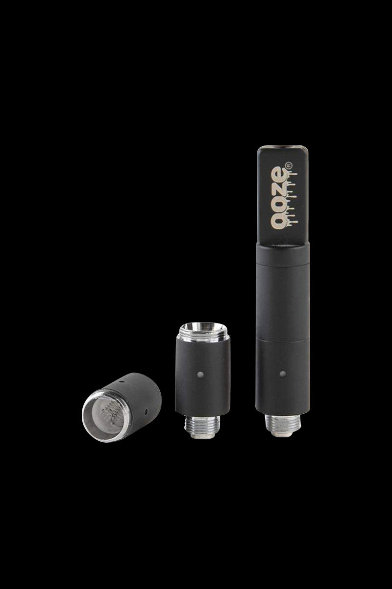 Three-quarter view of a disassembled black Ooze Slim Twist Pro Wax Atomizer Tank showing the mouthpiece, center chamber, and base against a black background