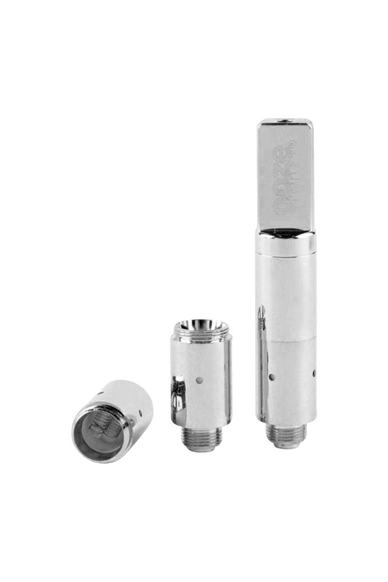 Three-piece arrangement photographed front-on of the chrome Ooze Slim Twist Pro Wax Atomizer Tank showing the assembled tube at right and two disassembled atomizer cores to its left.