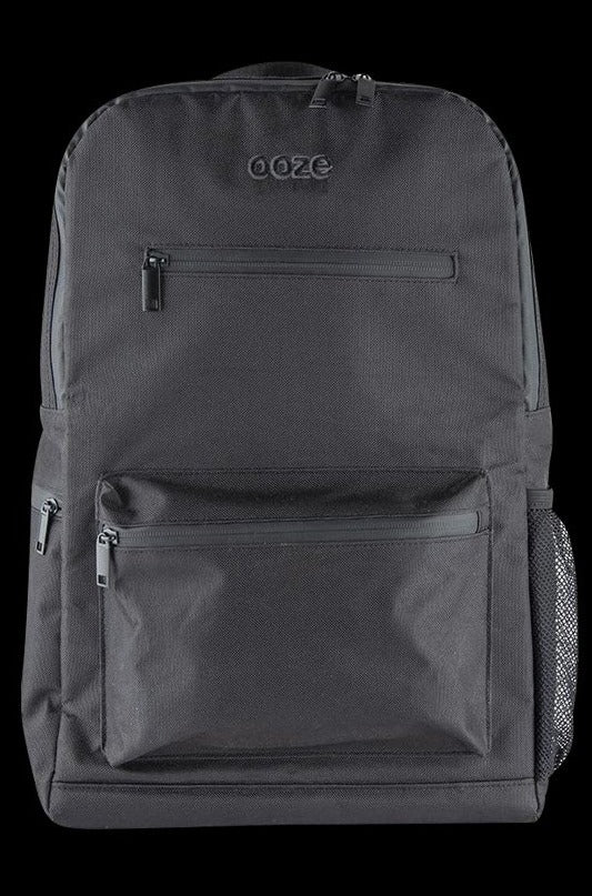 Front view of the Ooze Smell Proof Backpack, a dark-colored bag with a zipper pocket against a plain, dark background.
