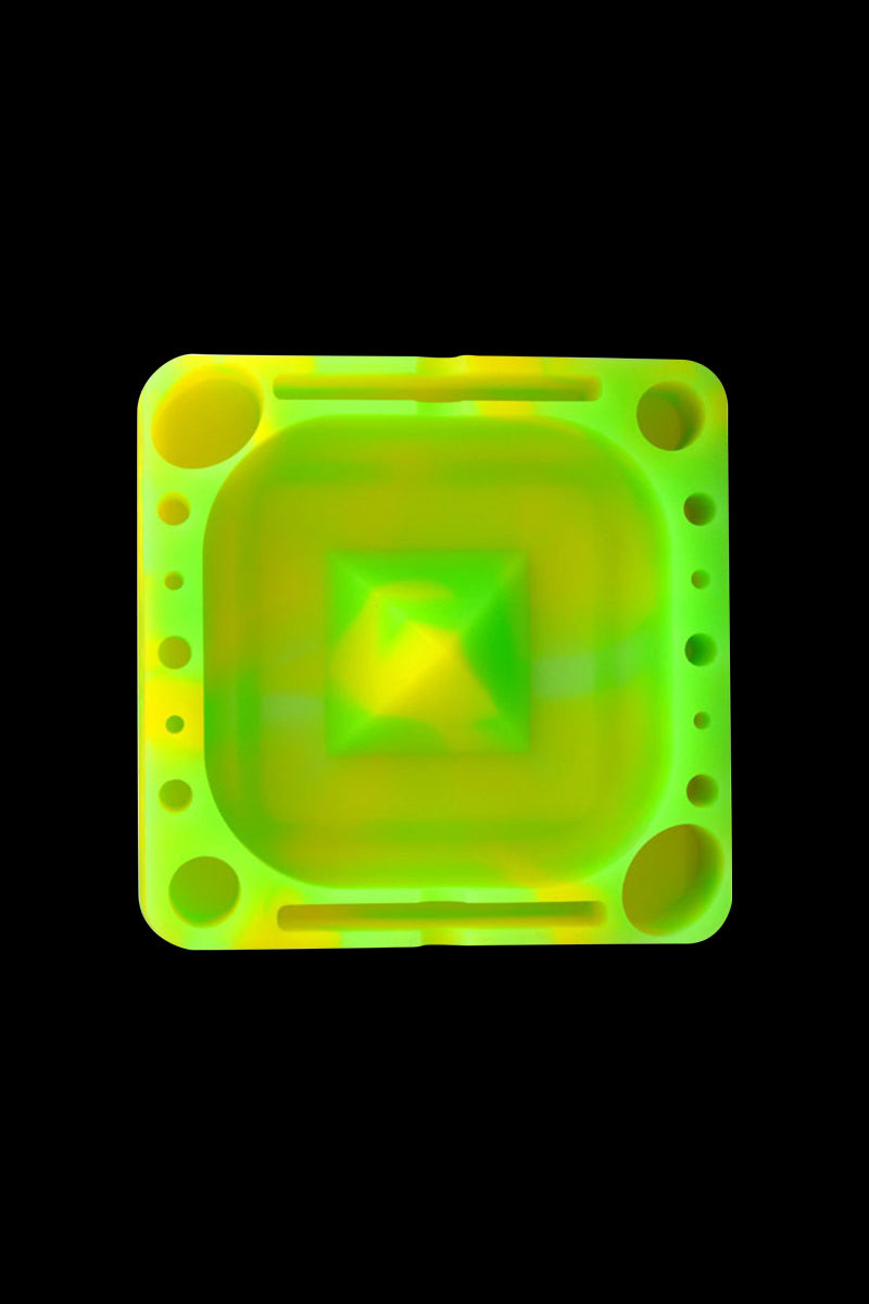 Top-down view of a neon green and yellow Pulsar Tap Tray centered on a black background, showing its square bowl and multiple round wells.