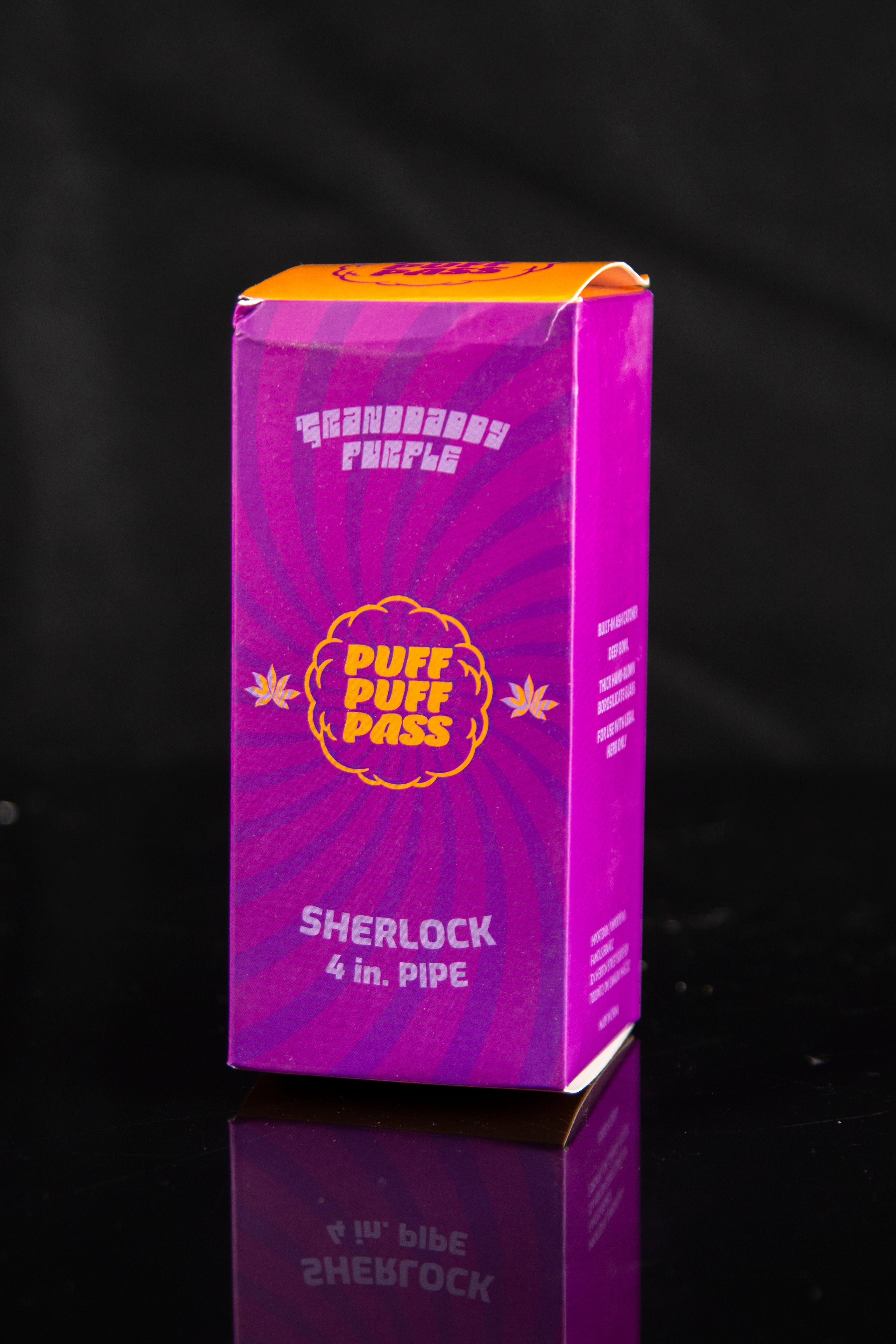 Purple box for a “Sherlock 4 in.” pipe with cannabis leaf graphics, reflected on a black surface.