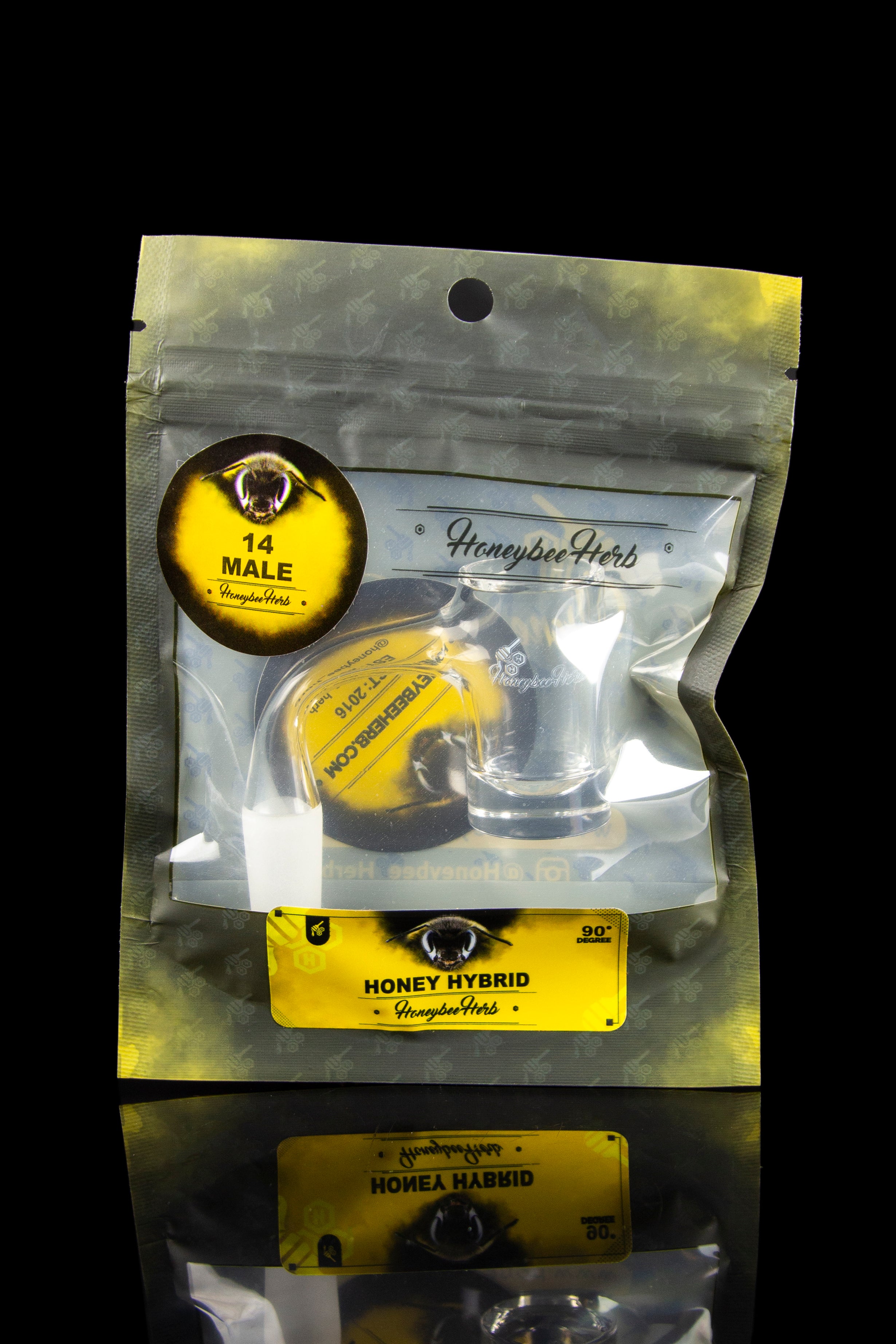 A sealed, clear mylar bag containing a glass cannabis concentrate container labeled “Honeybee Herb” with branding elements, displayed against a dark background.