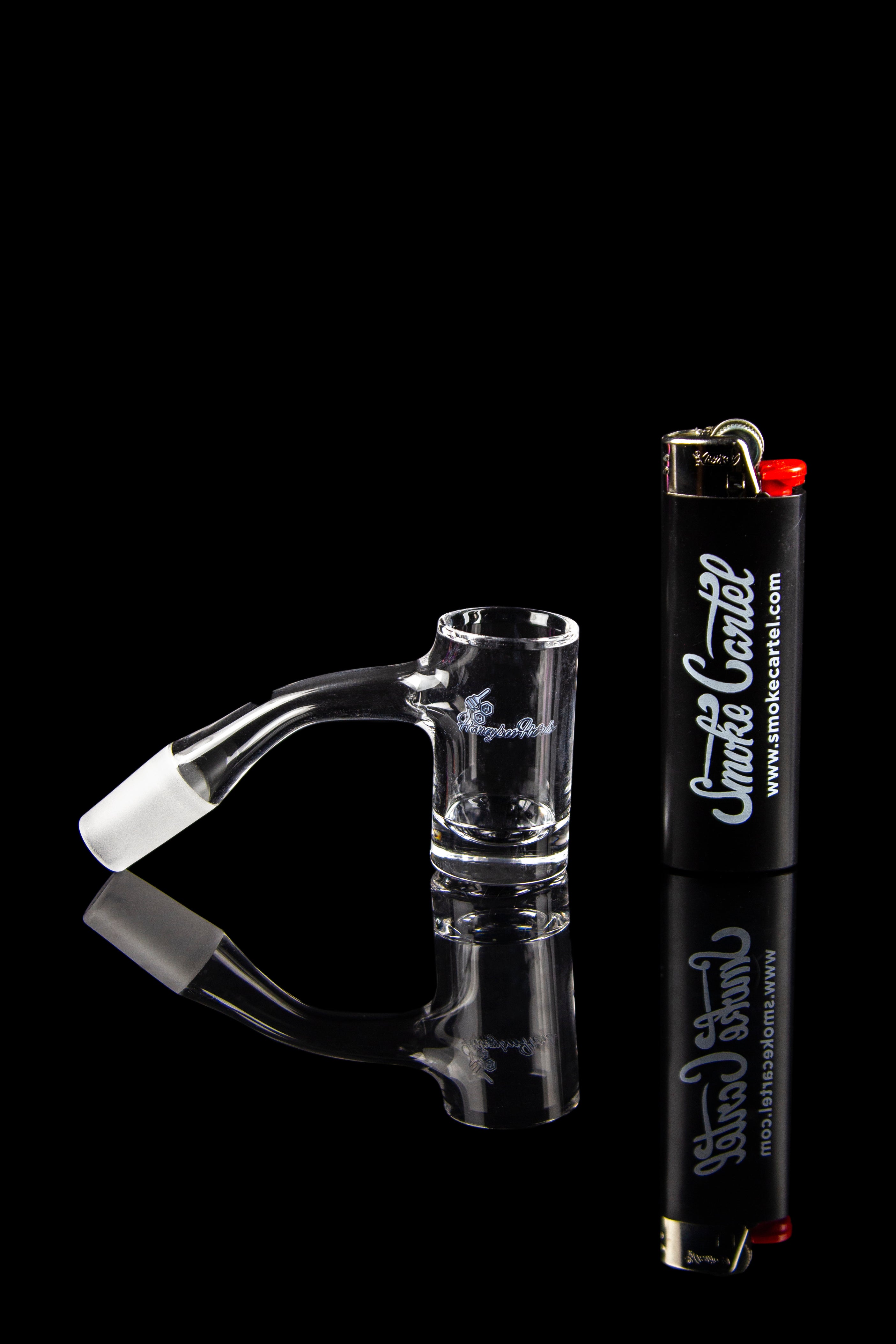 Glass cannabis oil rig with a lighter, studio shot.