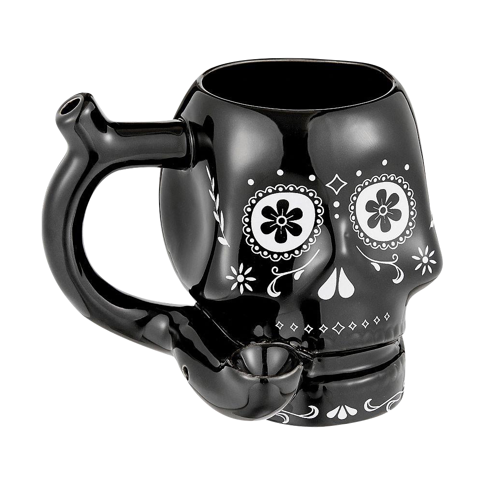 Three-quarter view of the Roast & Toast "Sugar Skull" Ceramic Pipe Mug showing a glossy black skull-shaped mug with white floral eye designs and a built-in pipe handle.