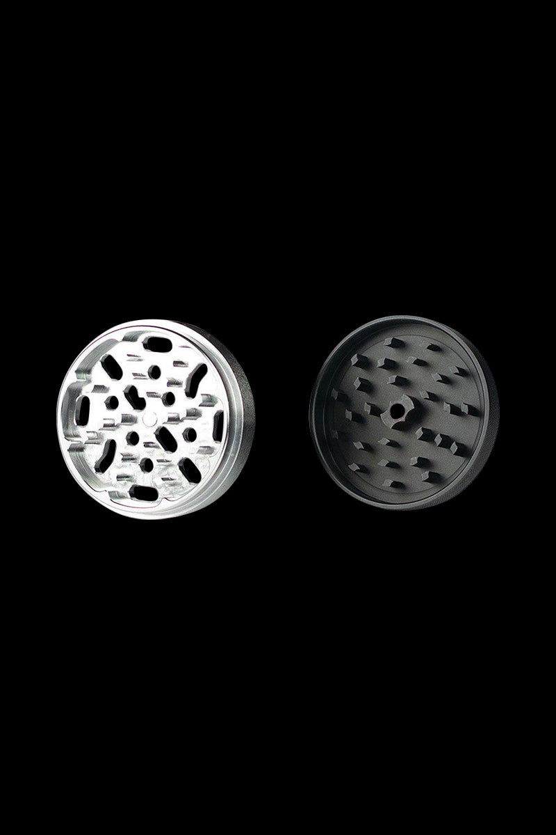 A close-up, top-down view of the Kannastor 4-Piece Solid Body Grinder, showcasing its metallic, multi-tiered design.