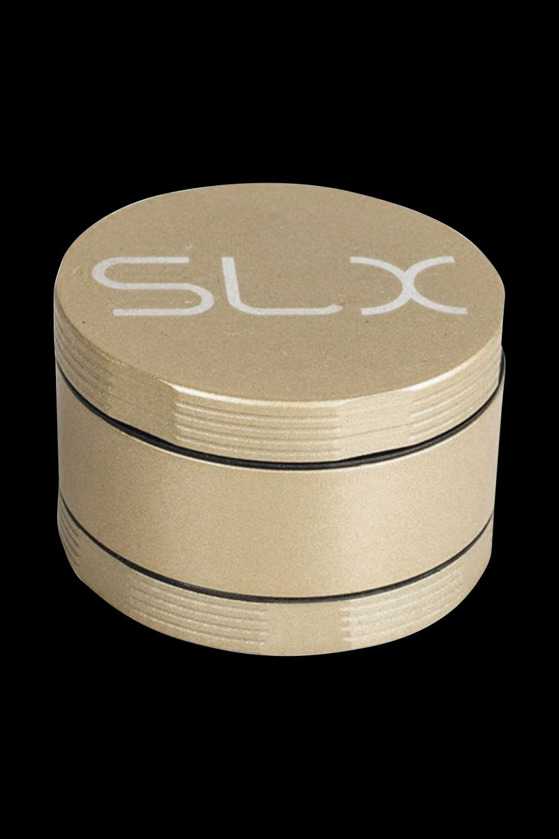 Front three-quarter view of the gold SLX Ceramic Coated 2.2" Pocket Grinder on a black background, showing its stacked ridged sections and white SLX logo on top.