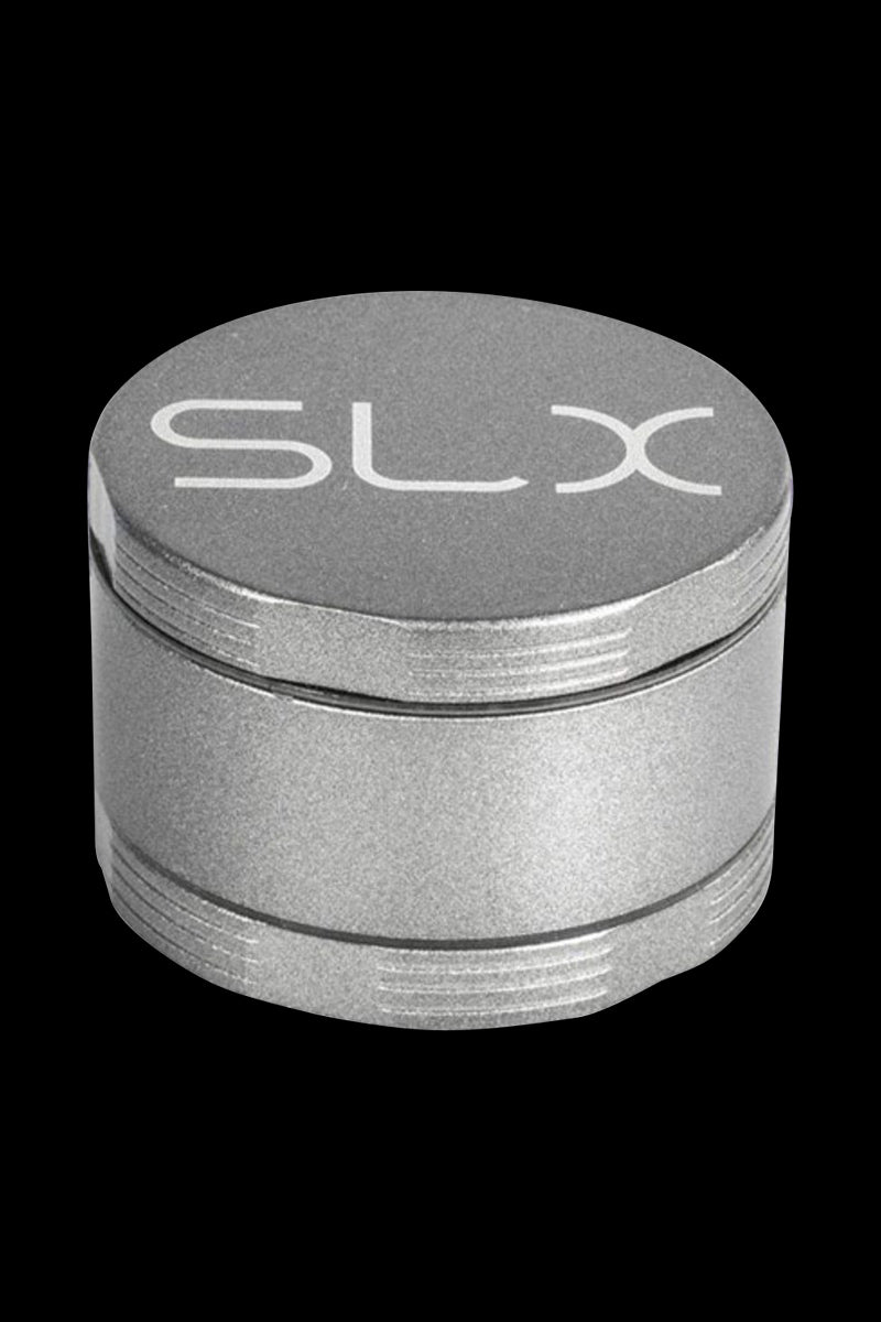 Close-up front view of the silver SLX Ceramic Coated 2.2" Pocket Grinder on a solid black background showing its round stacked chambers and embossed SLX logo on the lid.