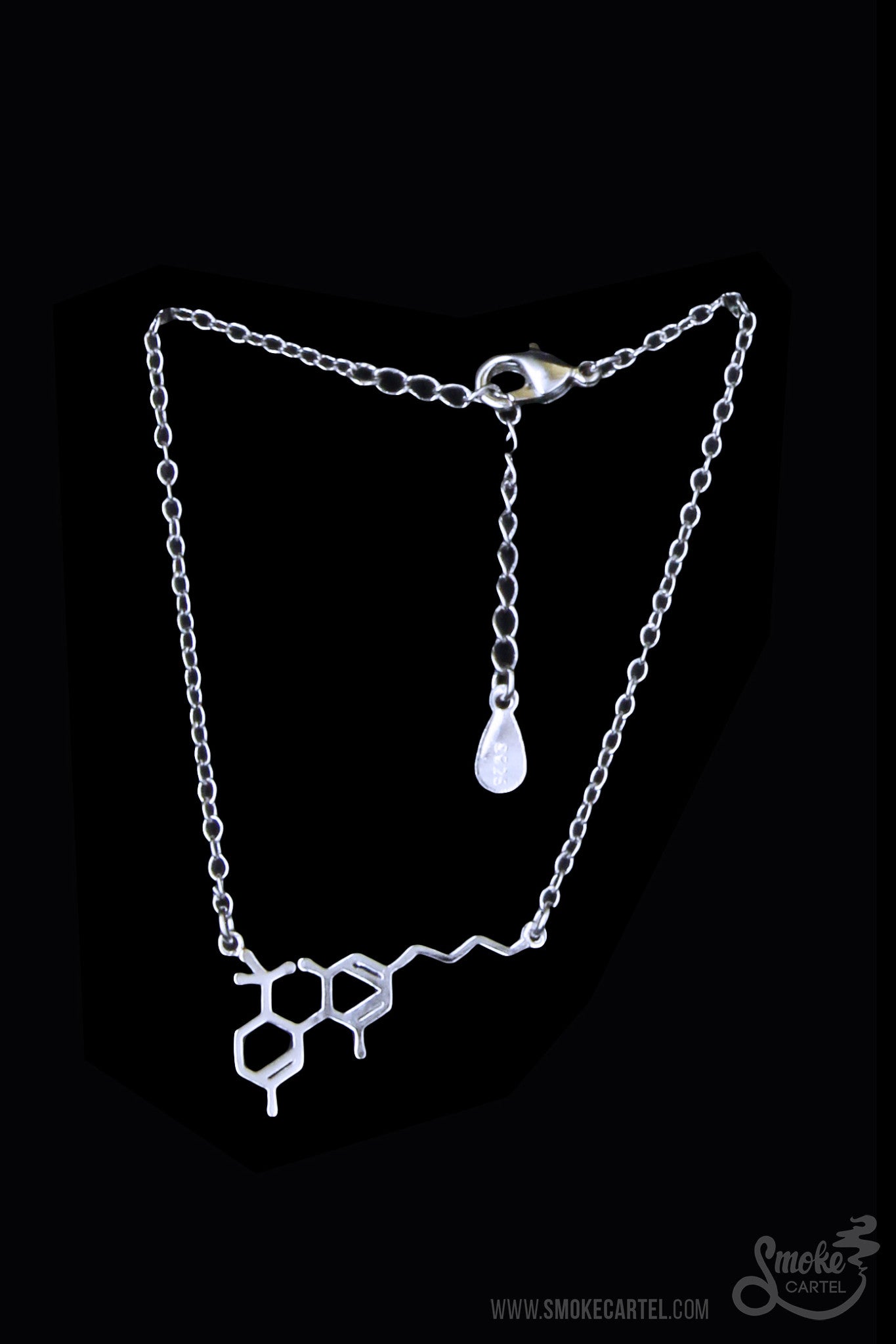 A close-up of the silver Smoke Cartel THC Molecule Bracelet, showcasing the detailed pendant against a blurred background.