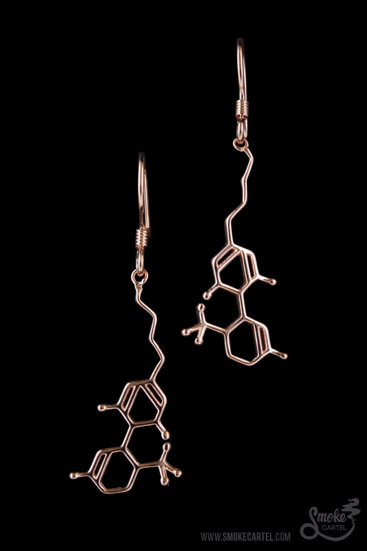 A close-up shot of the Smoke Cartel THC Molecule Earrings, displaying the detailed, silver-toned molecular structure against a dark background.