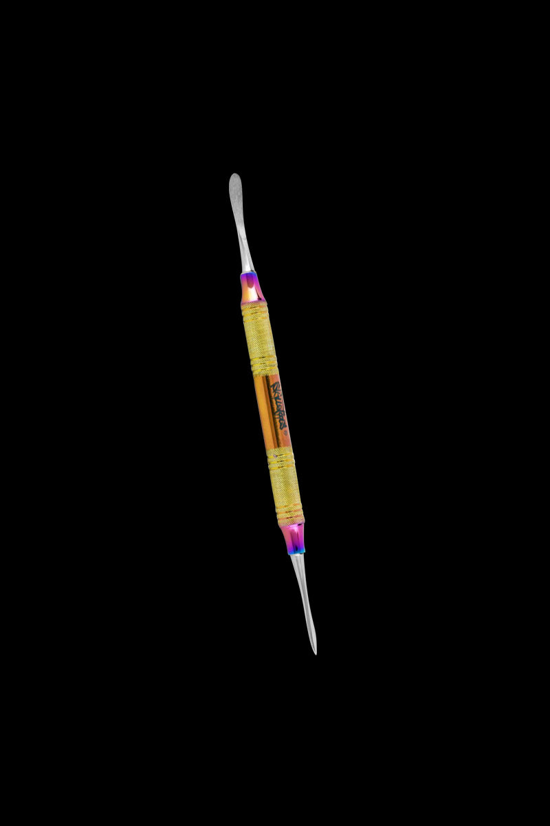 Angled close-up of a gold and rainbow Skilletools Anodized Series Dab Tools double-ended tool against a black background