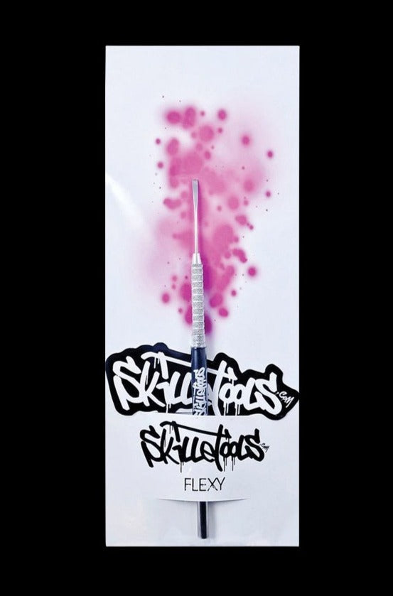 A close-up shot of the Skilletools Classic Series Metal Dab Tools with a shiny silver finish, angled against a blurred pink backdrop.