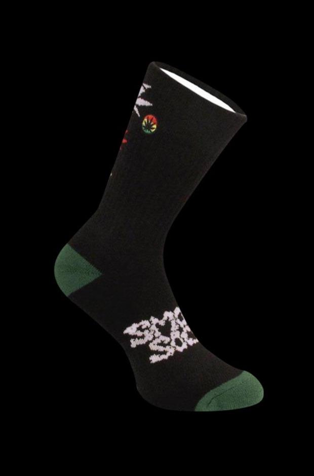 A side view of the Smokey Brand Socks - Hemp Leaf Ladder, showing a dark sock with a green toe against a black background.