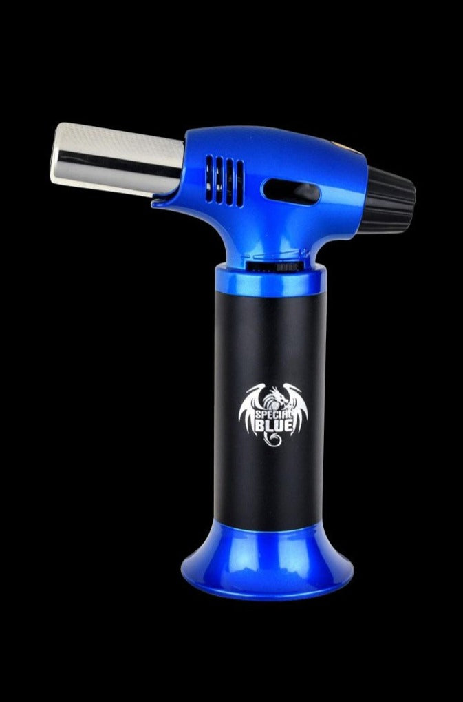 Center-frontal view of the silver and blue Special Blue Inferno Butane Torch standing upright against a black background, logo visible on the cylindrical body.