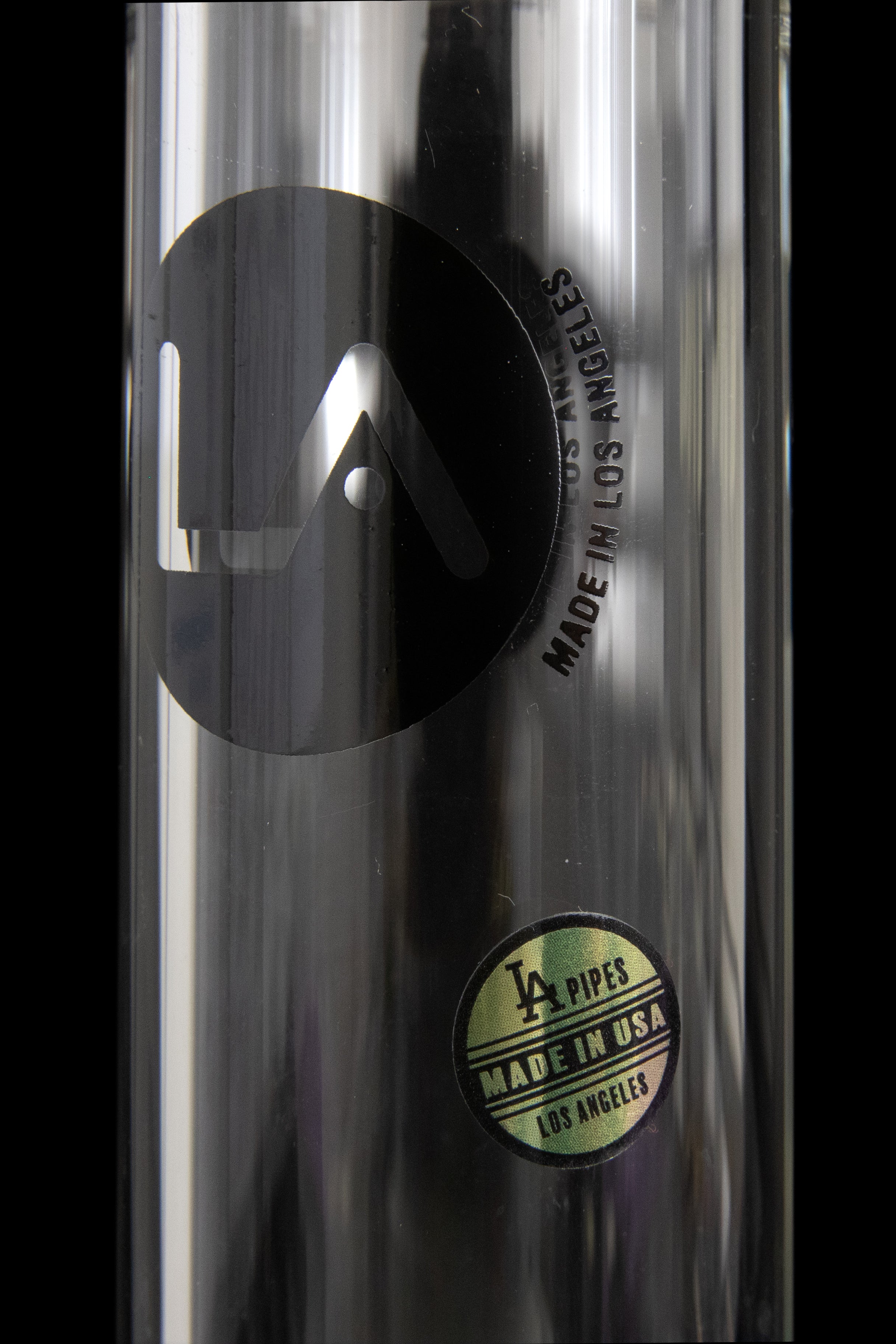 Close-up of a metallic cannabis pipe with a circular "LA PIPES - MADE IN USA - LOS ANGELES" label.