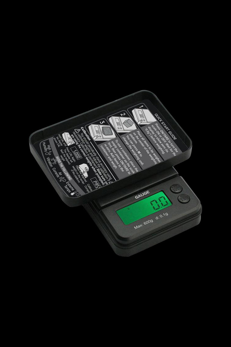 Angled close-up of the black Truweigh Gauge Digital Mini Scale - 600g x 0.1g with its flip-up weighing tray and green backlit LCD showing "0.0".