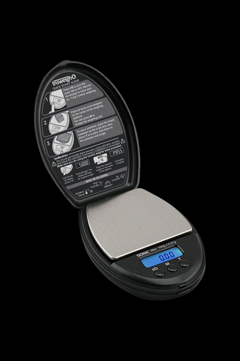 A close-up, angled view of the Truweigh Sonic Digital Mini Scale, displaying its digital readout and calibration instructions.